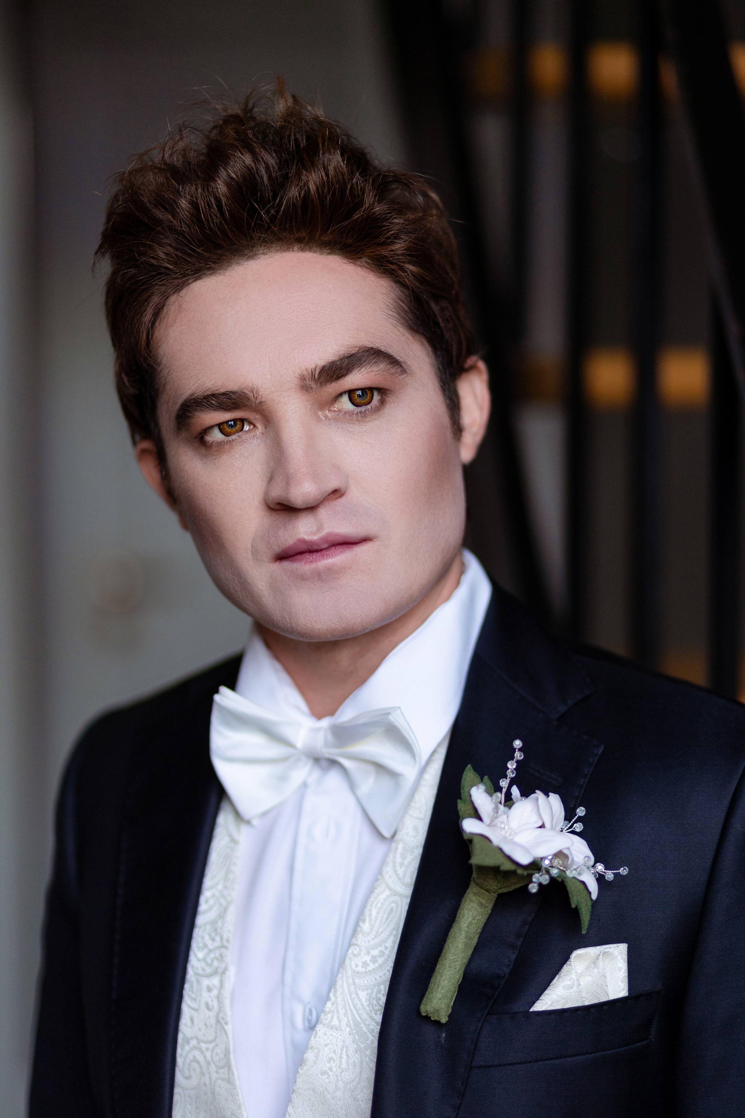 Бабочка, букет цветов в лацкане пиджака,платочек в кармане все белоснежного цвета.