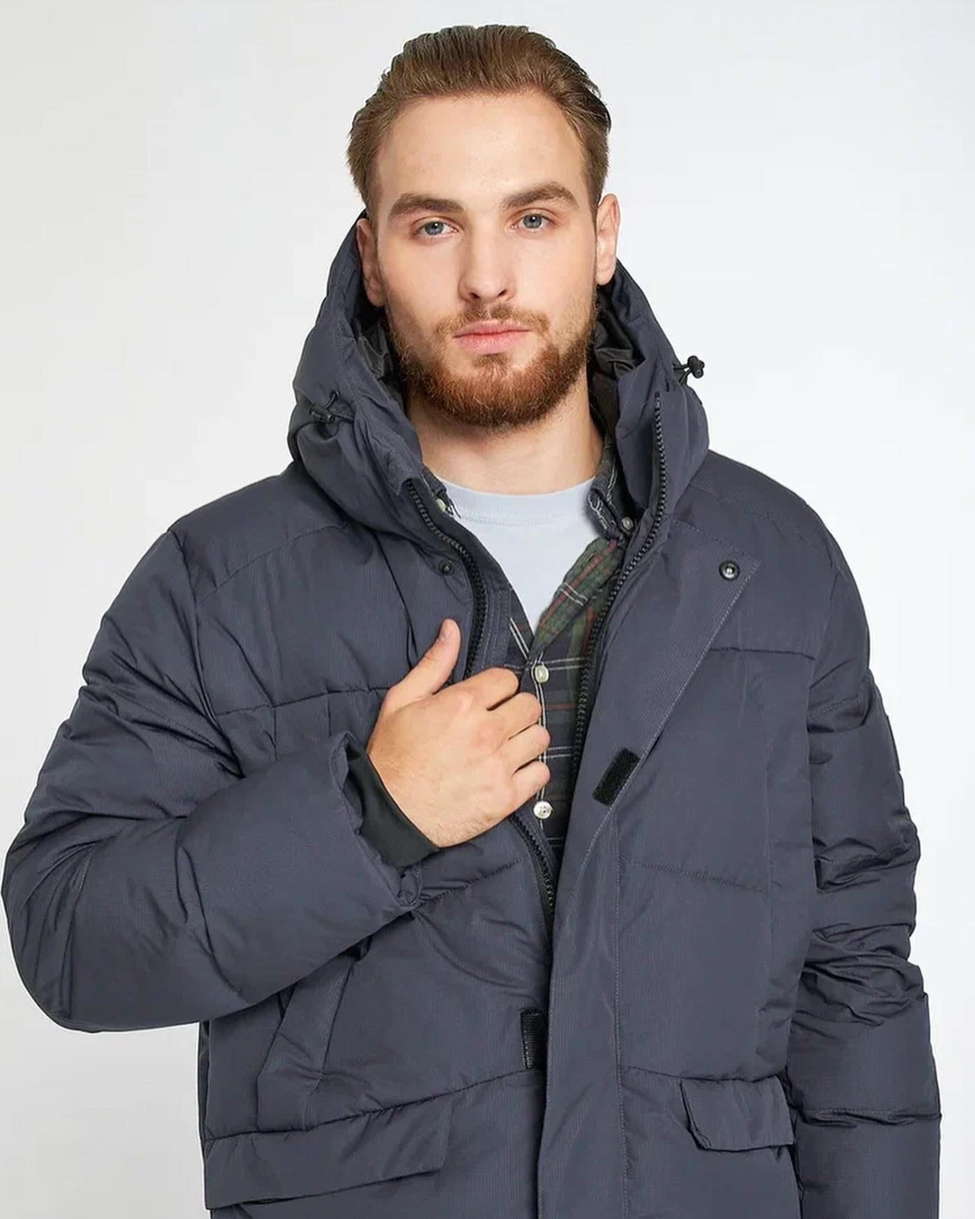 Мужчина с бородой в теплой куртке синего цвета на белом фоне