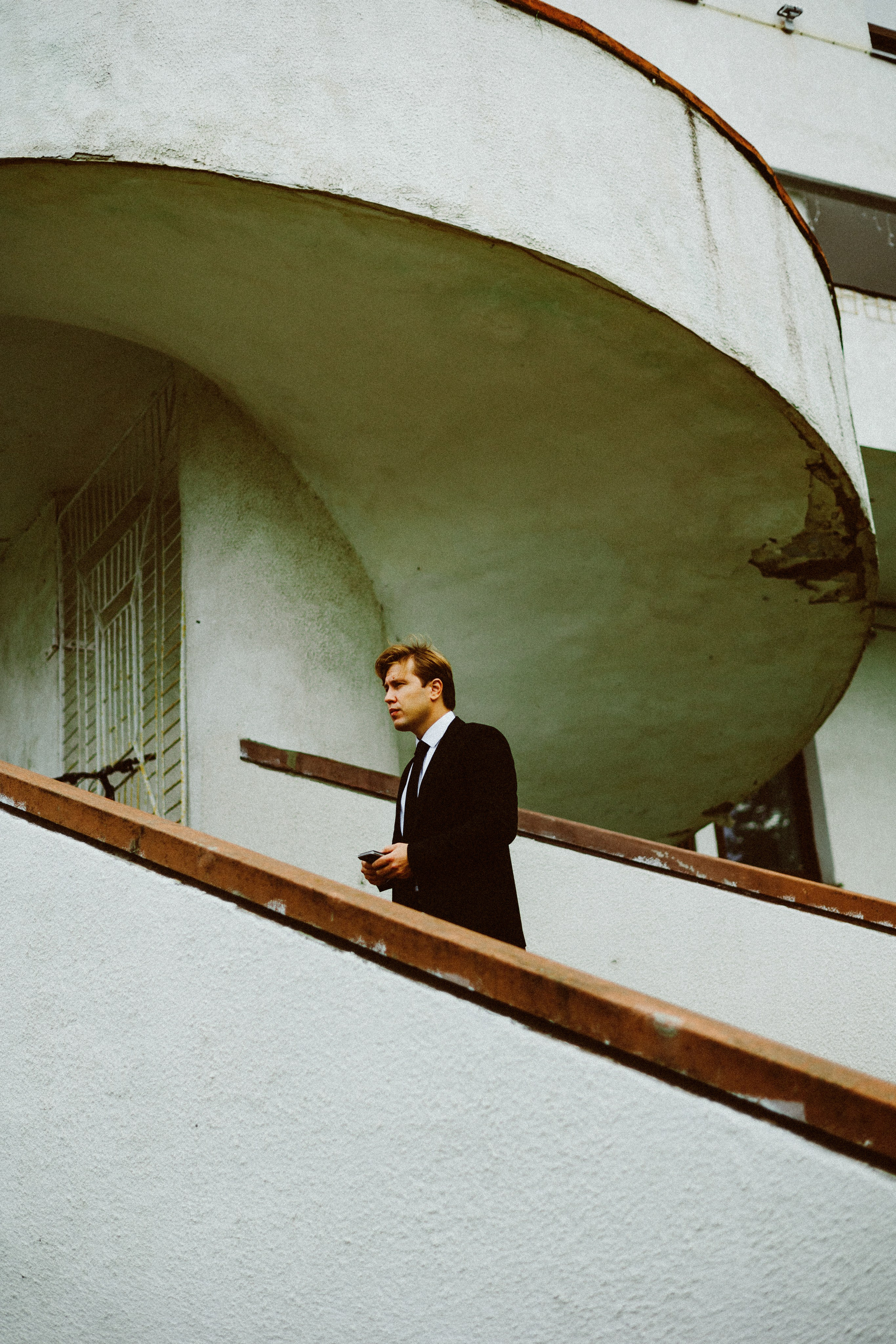 Молодой человек на винтовой лестнице с сигретой