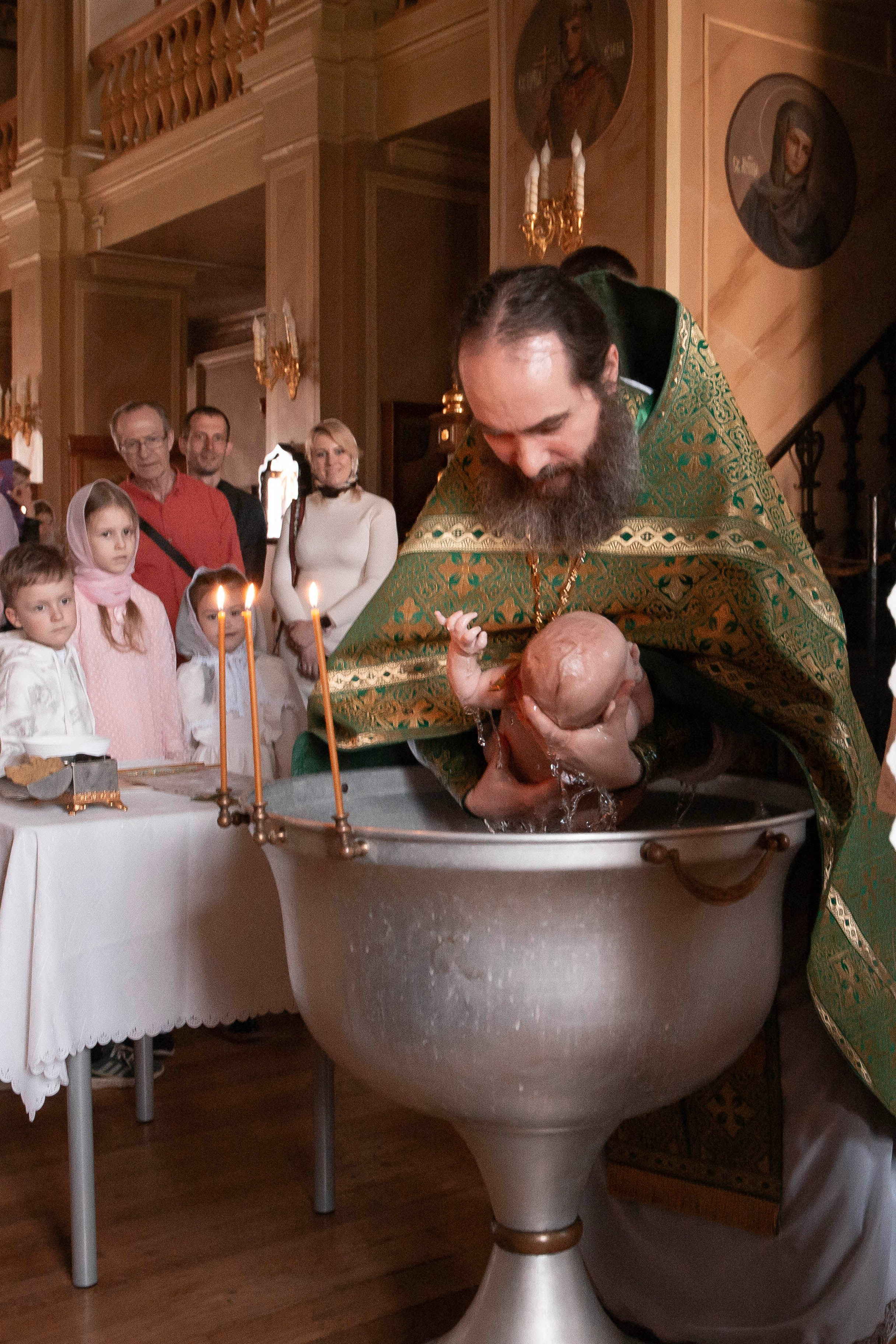 окунание малышки во время таинства крещения. Фото Юлия Щедрина