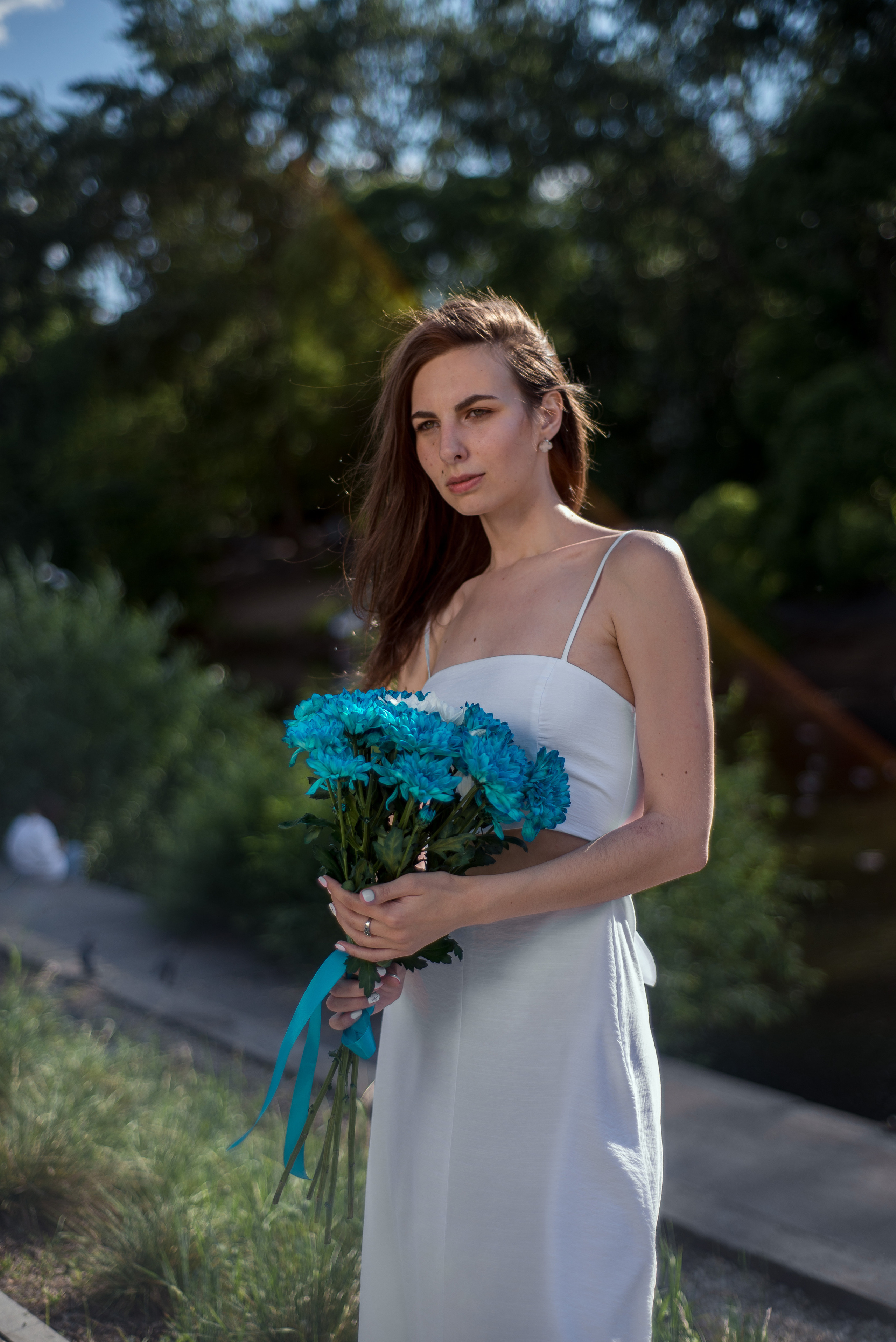 Невеста с букетом цветом в парке