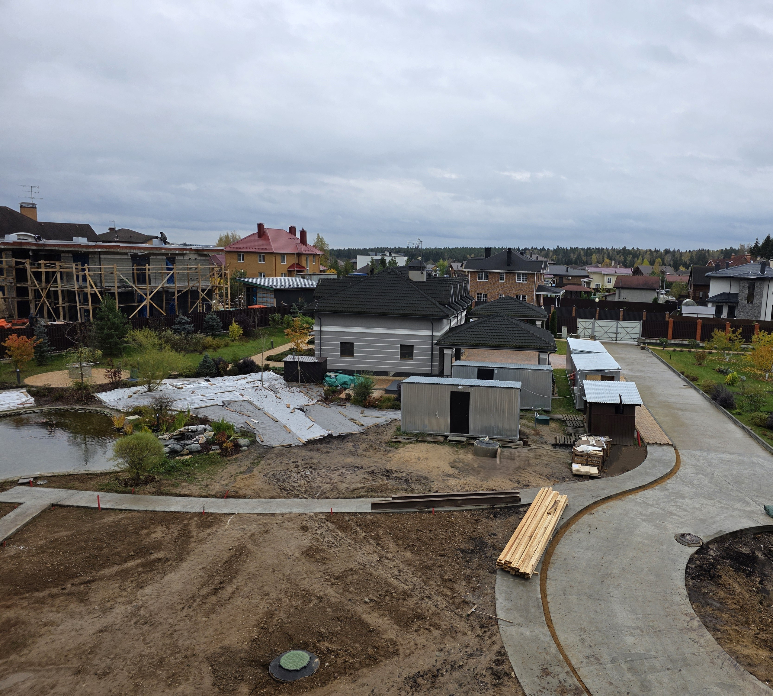 Общий вид участка с домом и бетонными дорожками — строительство в Подмосковье