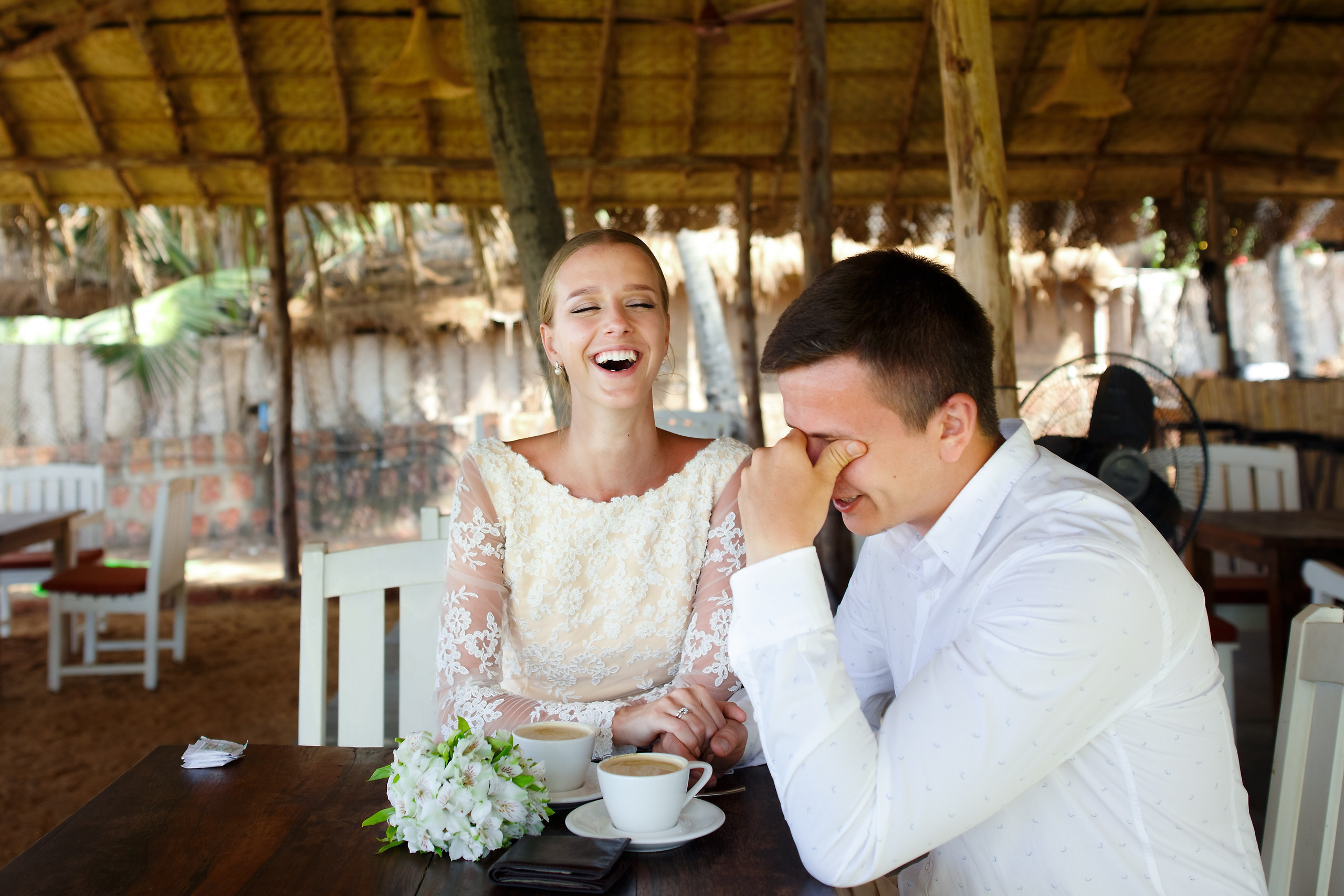 Невеста смеётся в ответ на слова жениха на свадебной фотографии. Счастье и любовь в кадре.