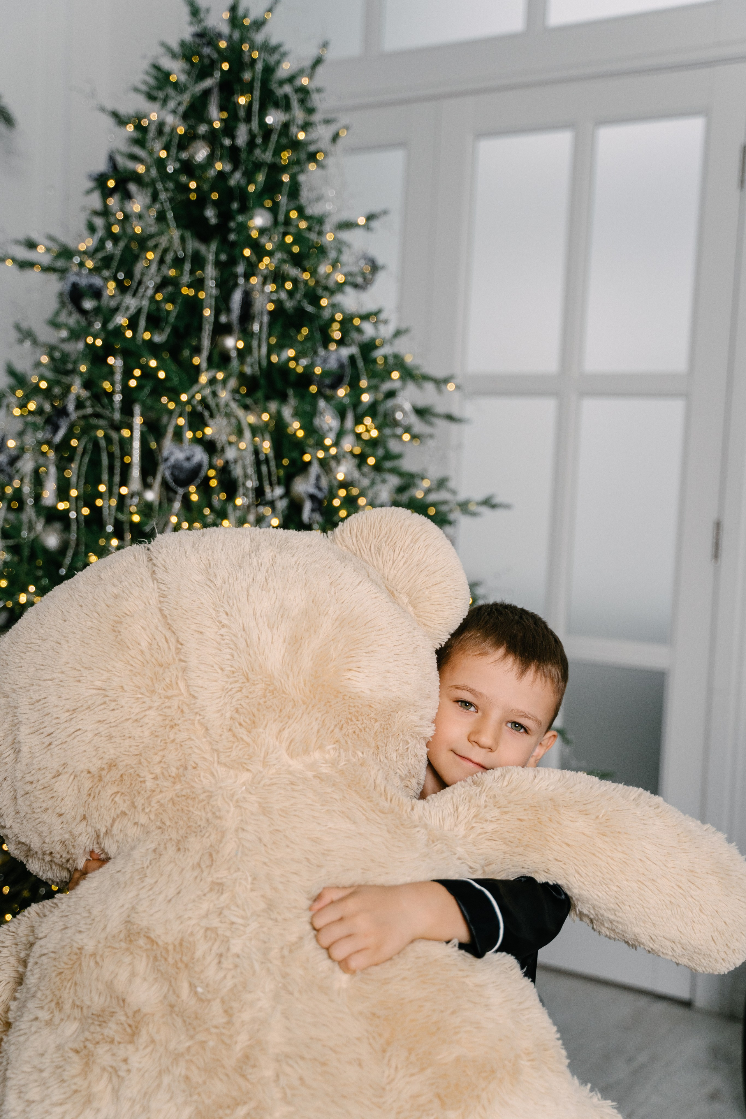 маленький мальчик обнимает медведя 