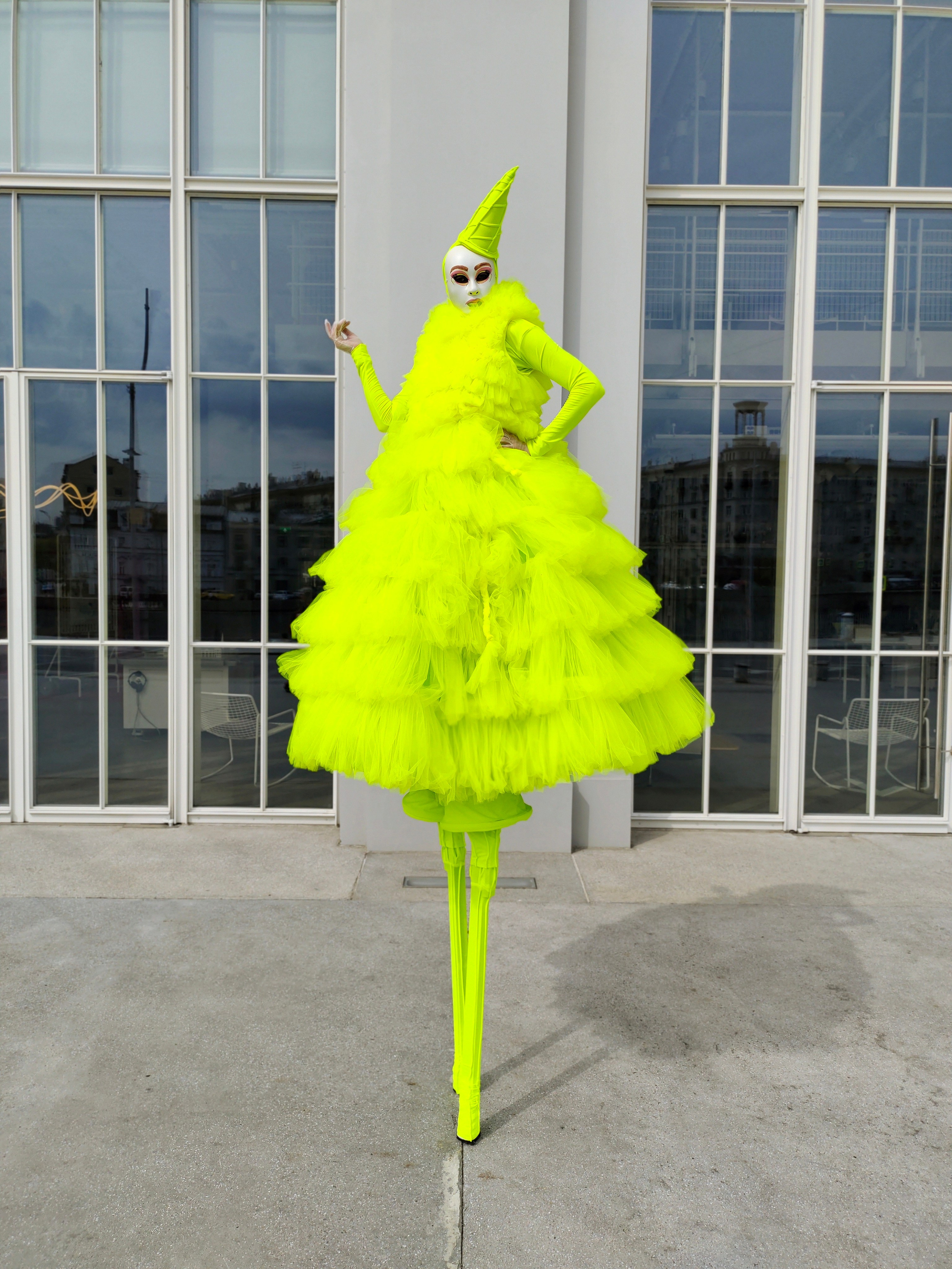 Мим на ходулях кокетничает с посетителями выставки на уличной велком-зоне