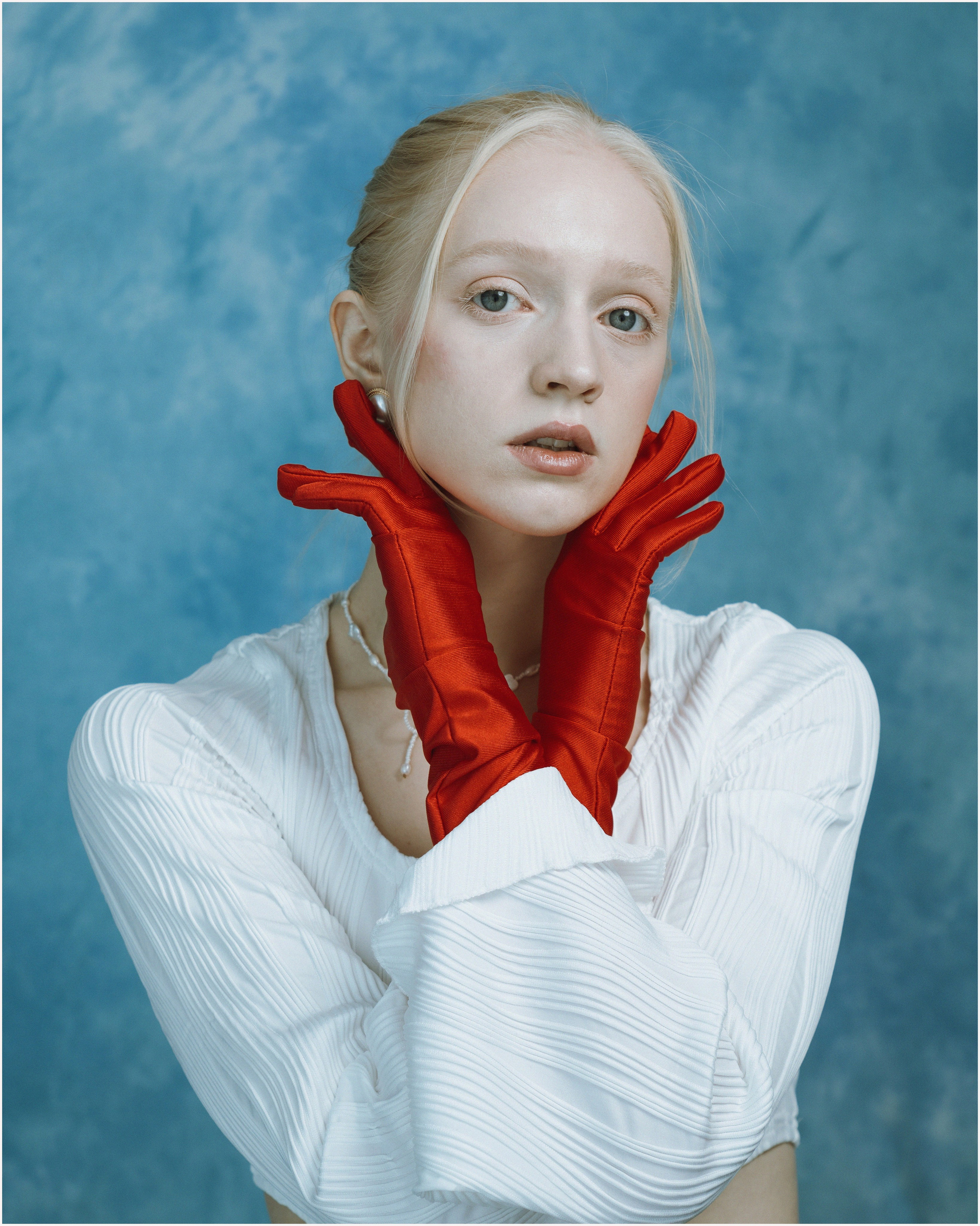 Девушка модель блондинка в красных перчатках на руках