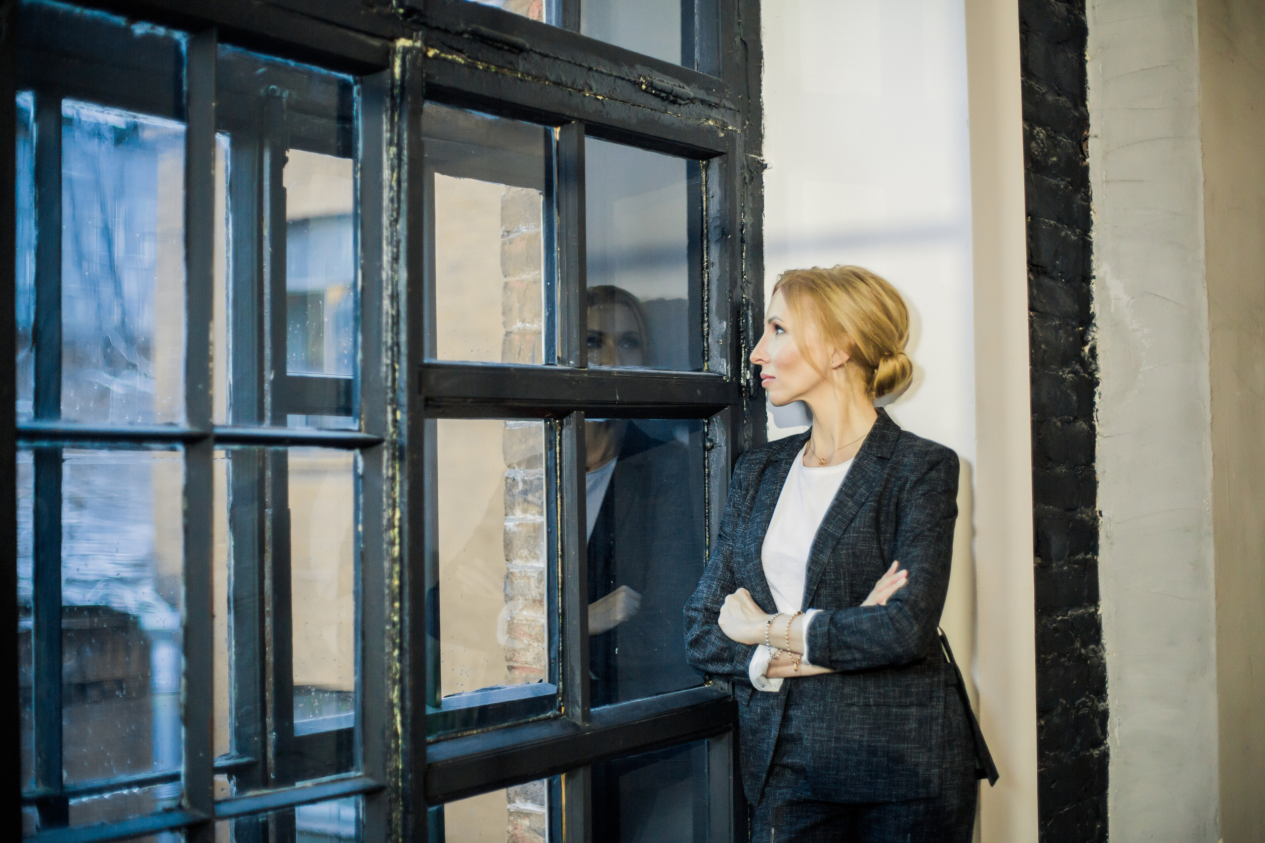 деловой студийный портрет женщины возле деревянного окна