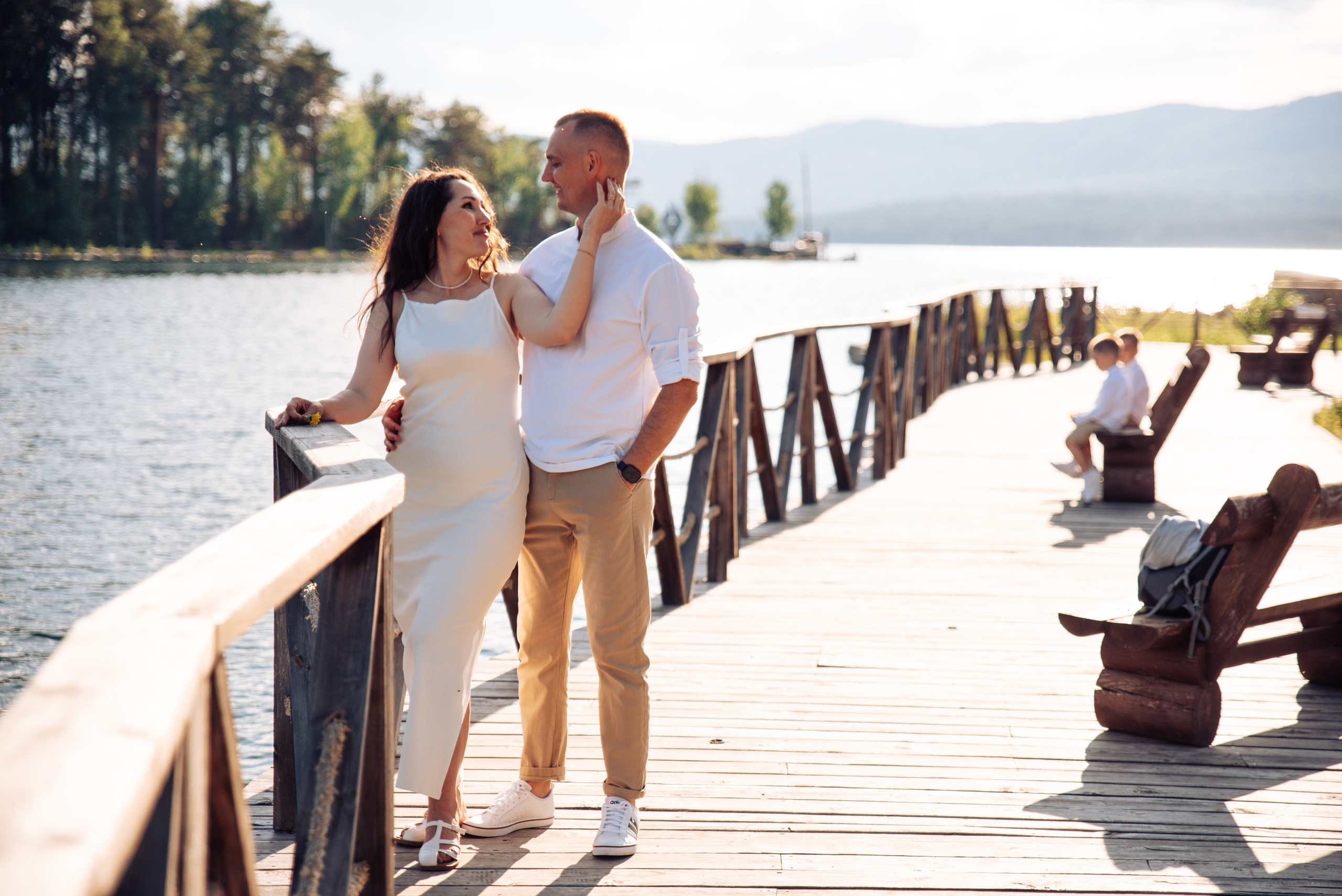 Семейная прогулка летом на берегу озера по пляжу