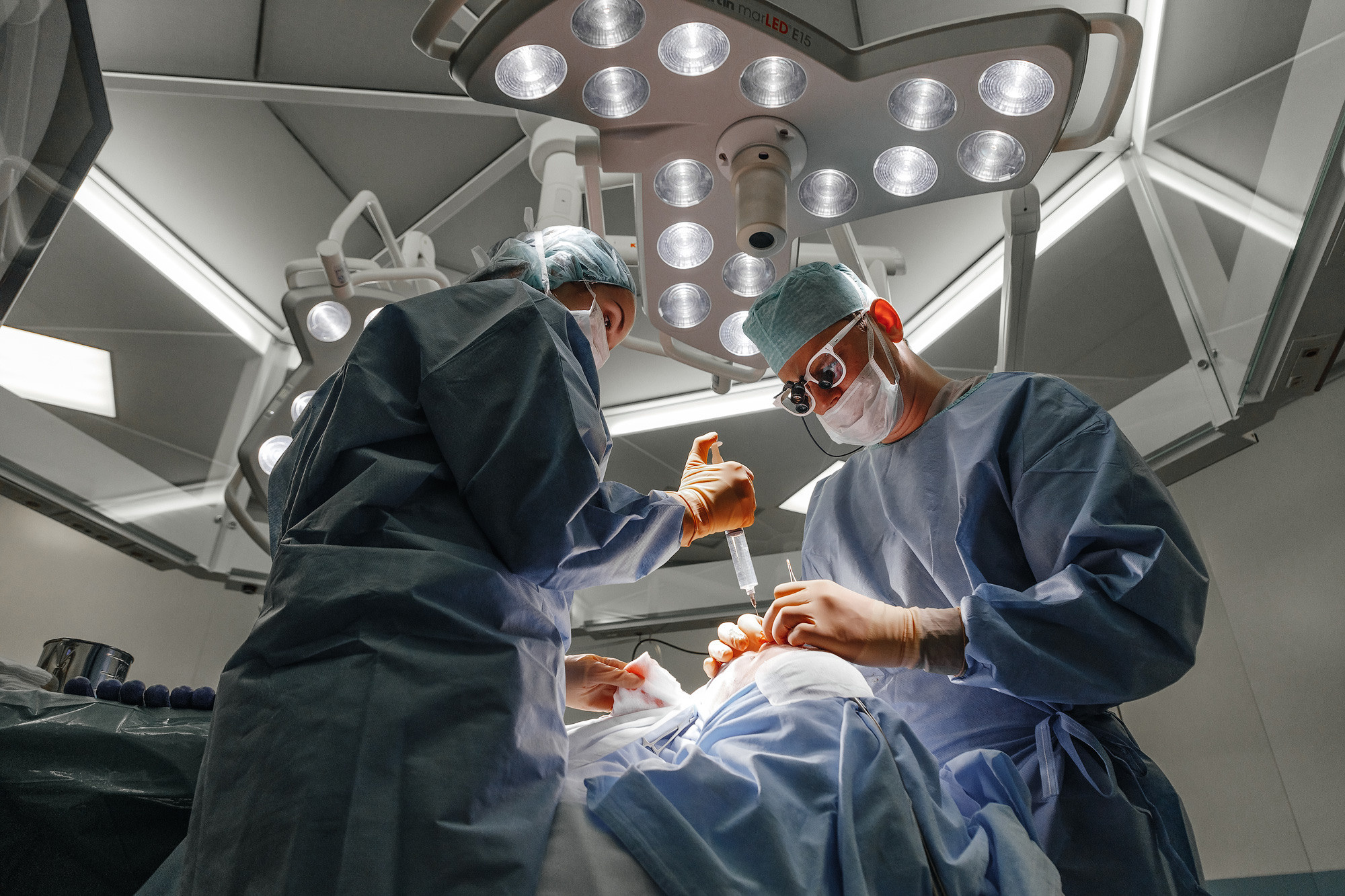 пластический хирург проводит операцию по ринопластике