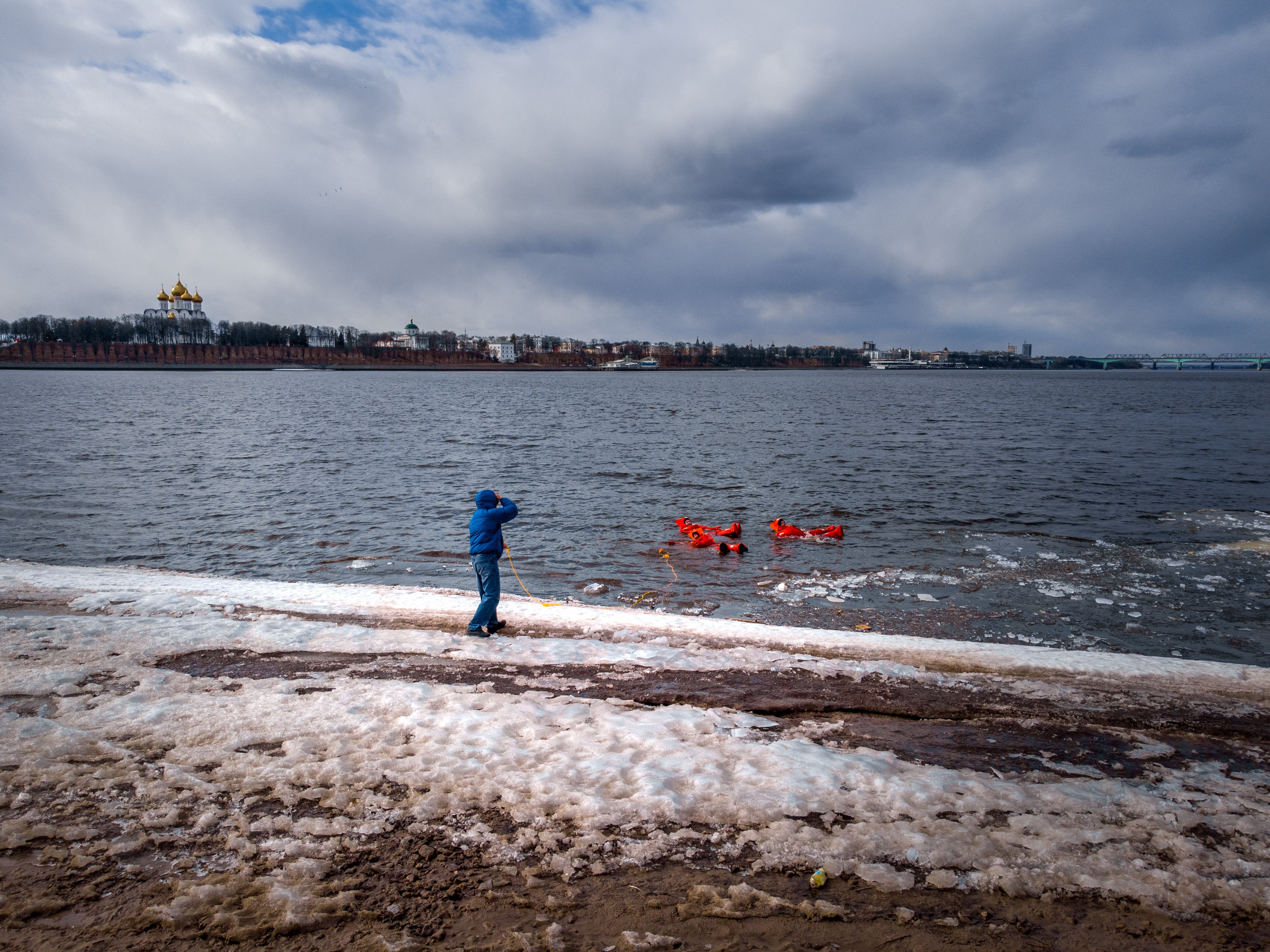 Люди купаются среди льдин, в спасательных оранжевых термо костюмах, айс флоатинг Ярославль