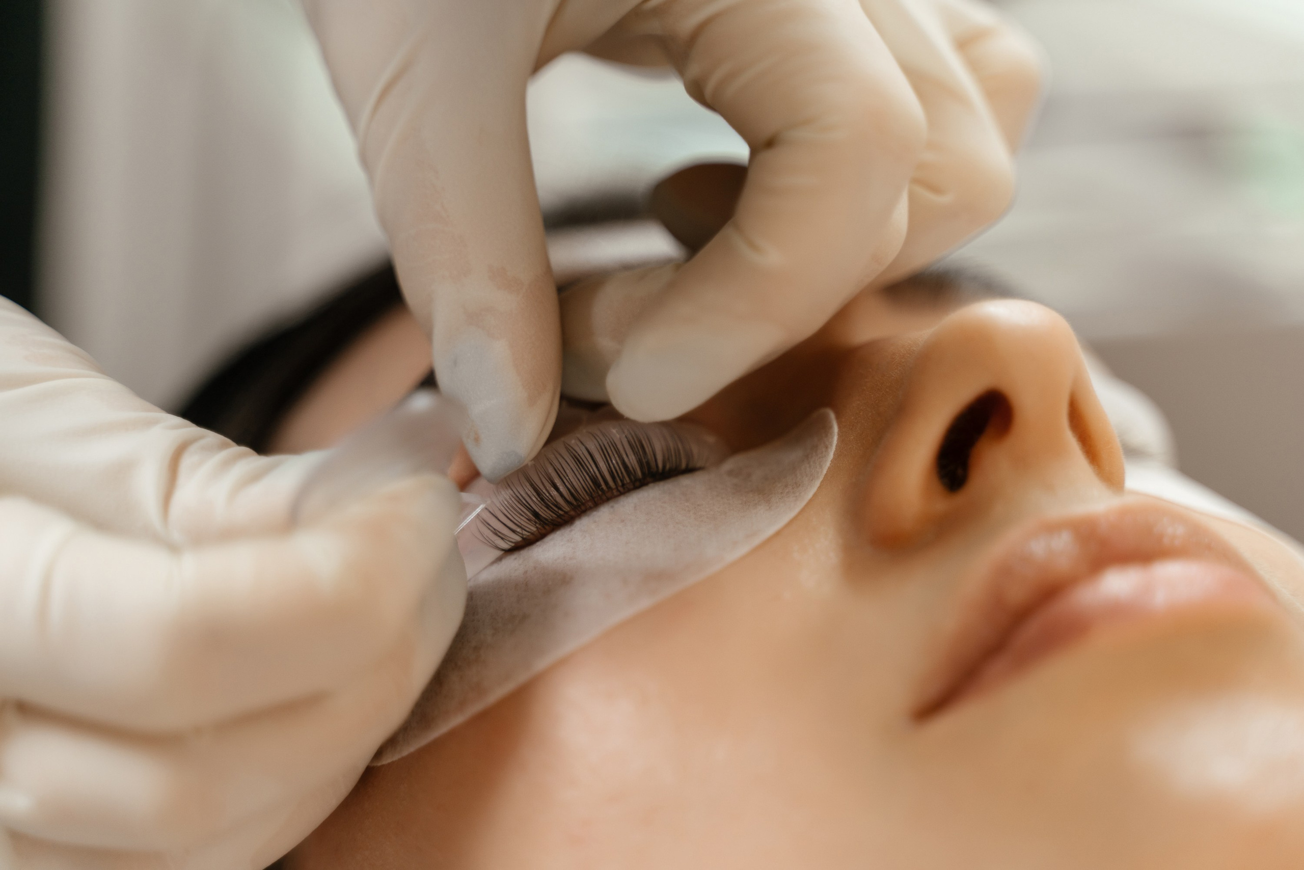 девушке клеят ресницы