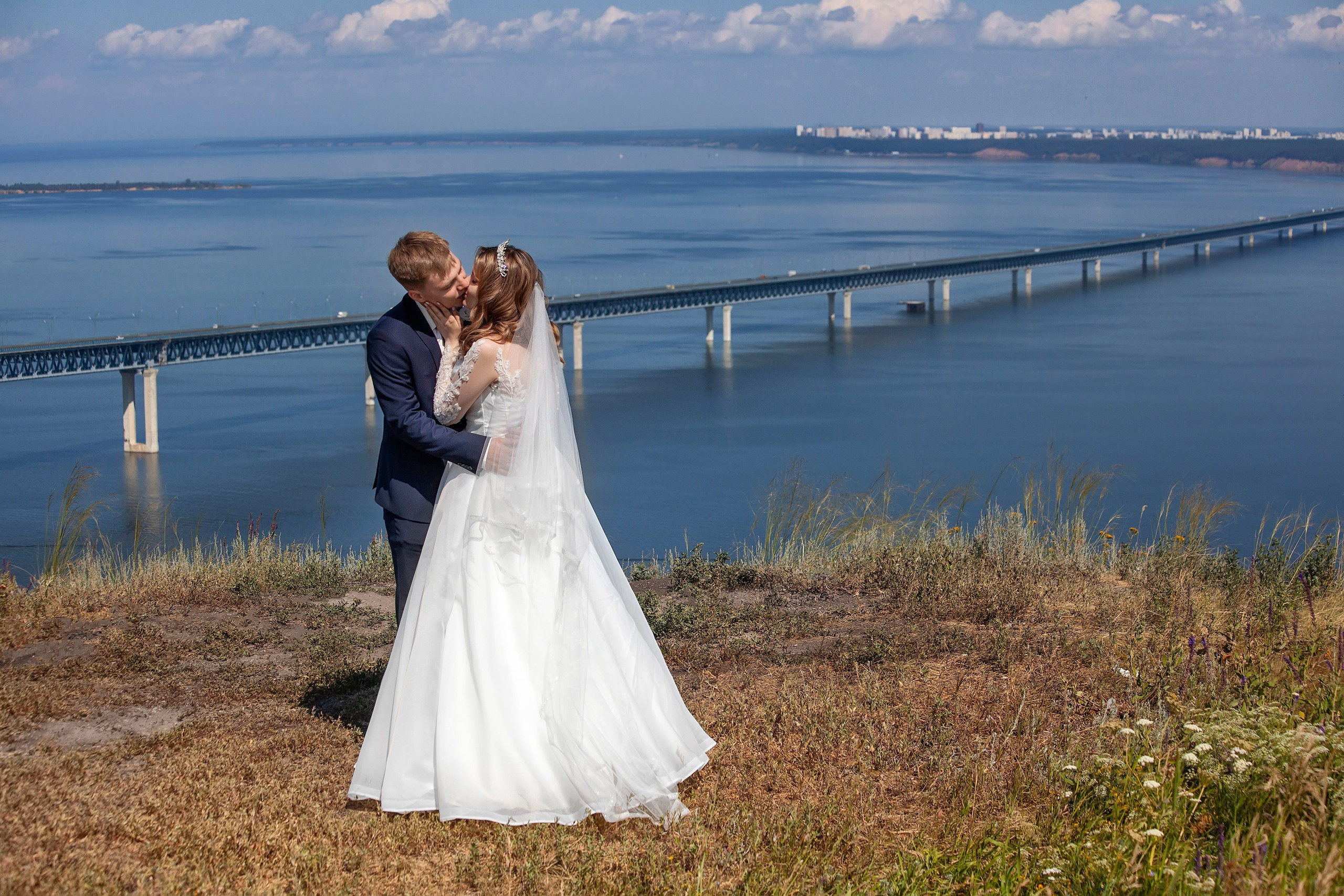 Молодые целуются на фоне моста - свадебные фотосъёмки в Ульяновске