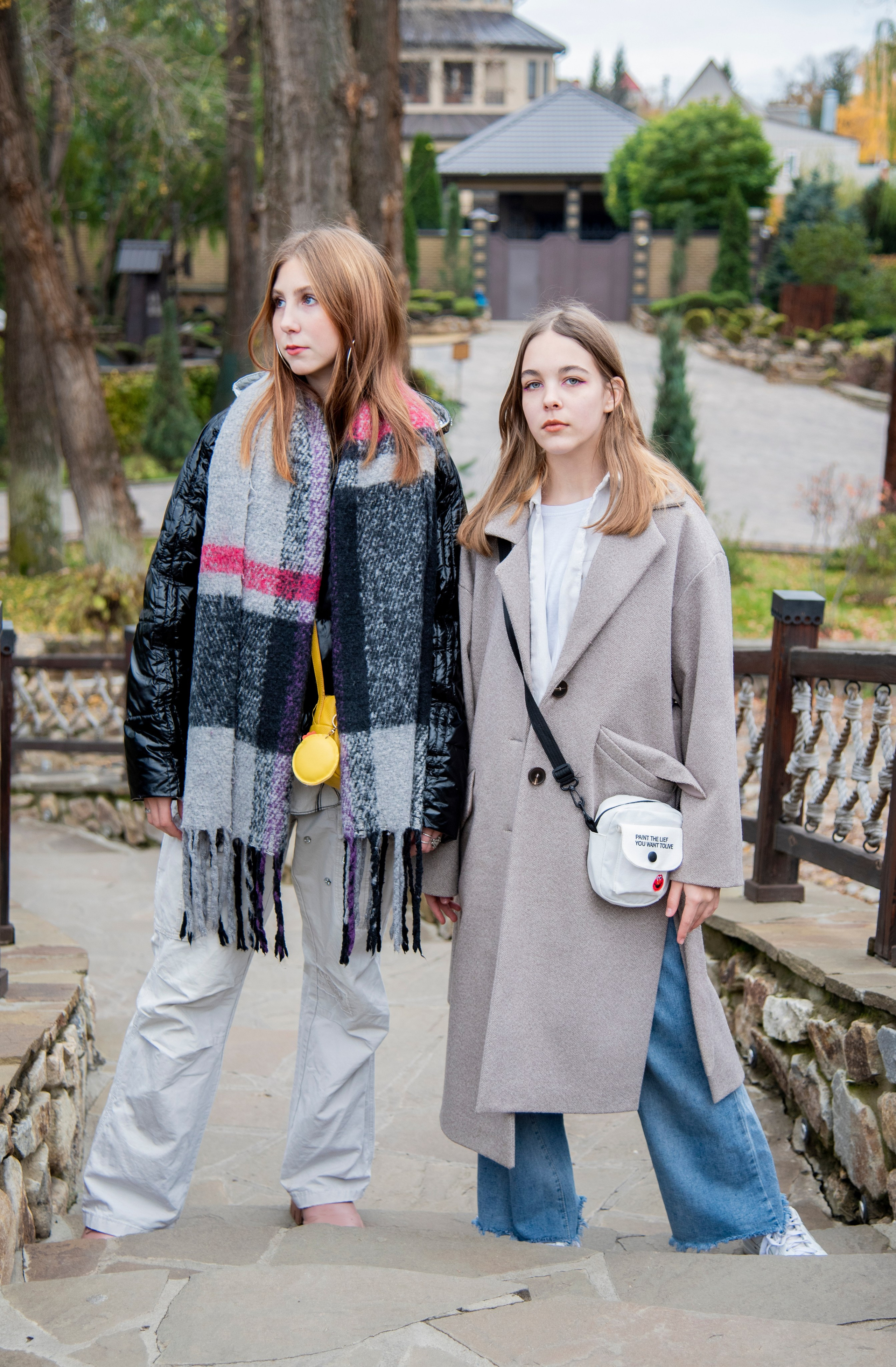 две девушки стоят рядом. серое пальто. чёрная куртка. парк лога. осень