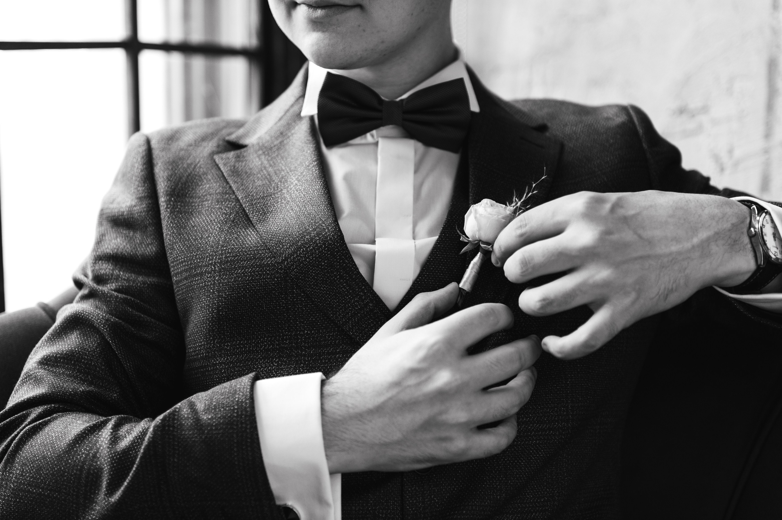 Жених поправляет бутоньерку.