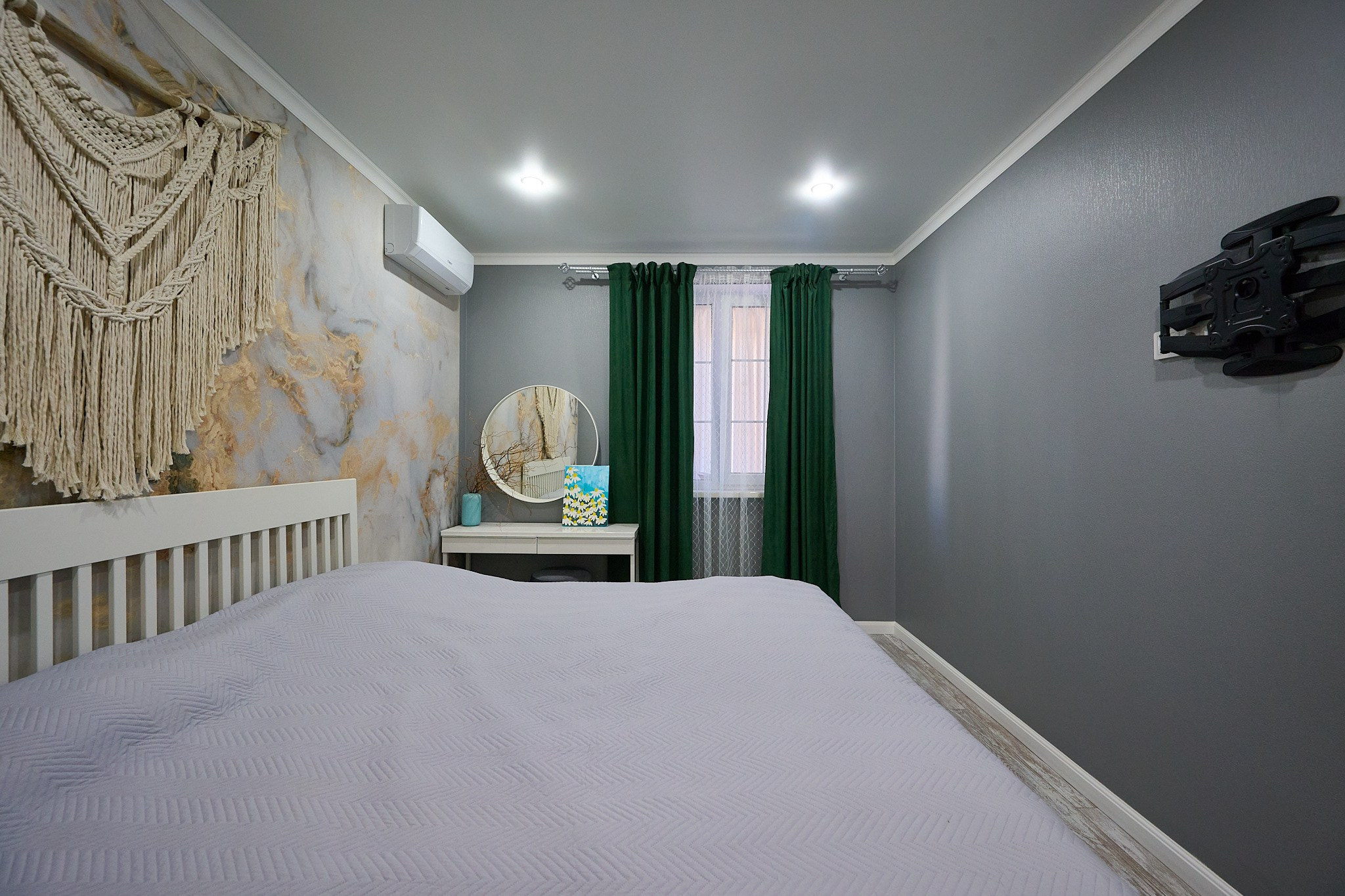 комната с серыми обоями темно зелеными шторами светлой кроватью 