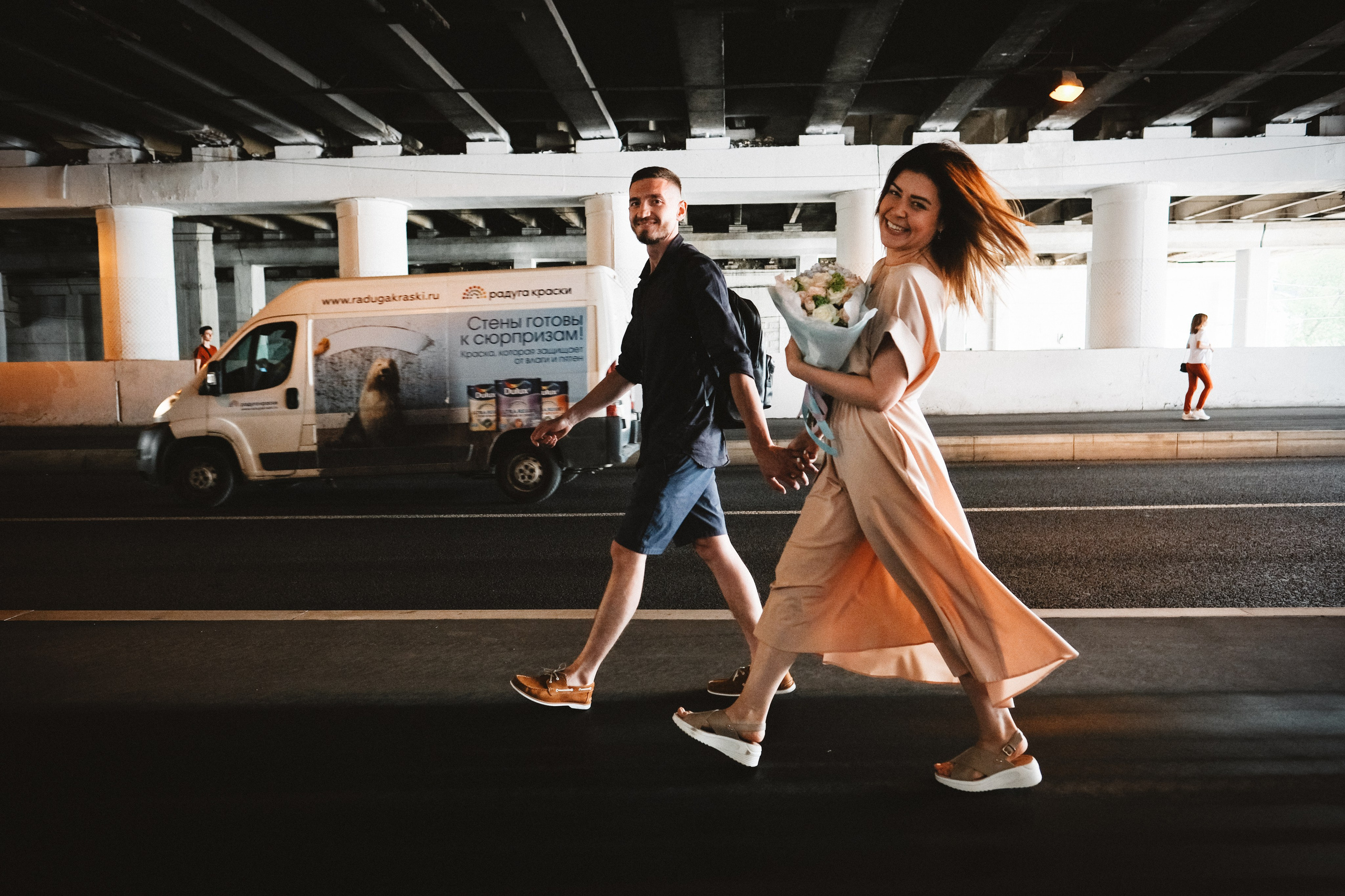 Пара молодоженов весело шагает по подземному переходу.