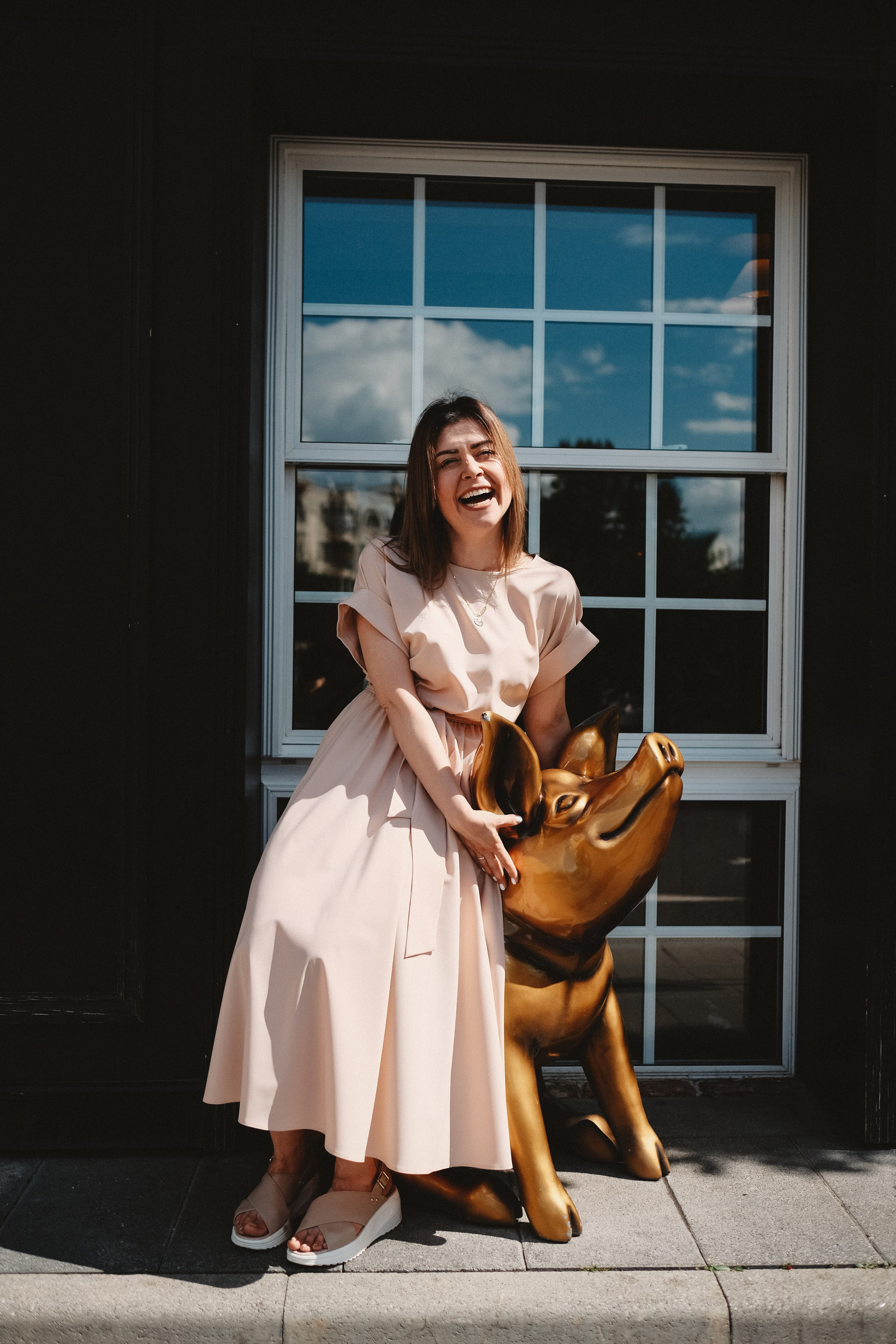 Ресторан Свинья и роза. Девушка в бежевом платье сидит на свинье.