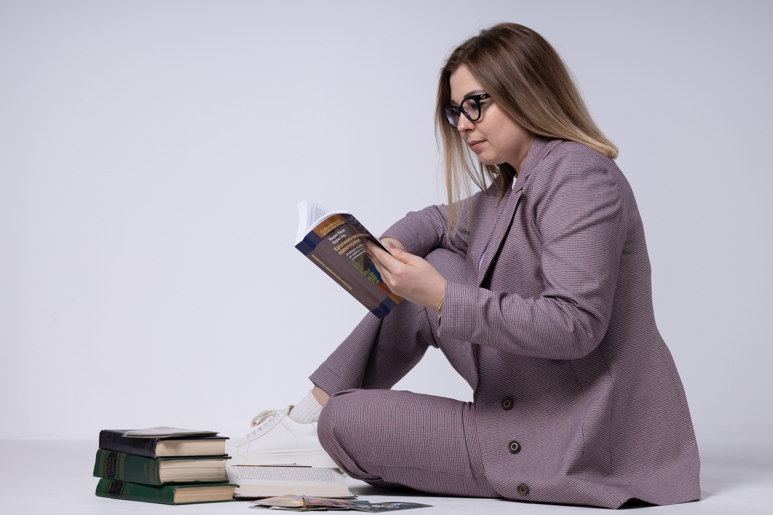 фотосессия в студии девушка в деловом костюме читает книги