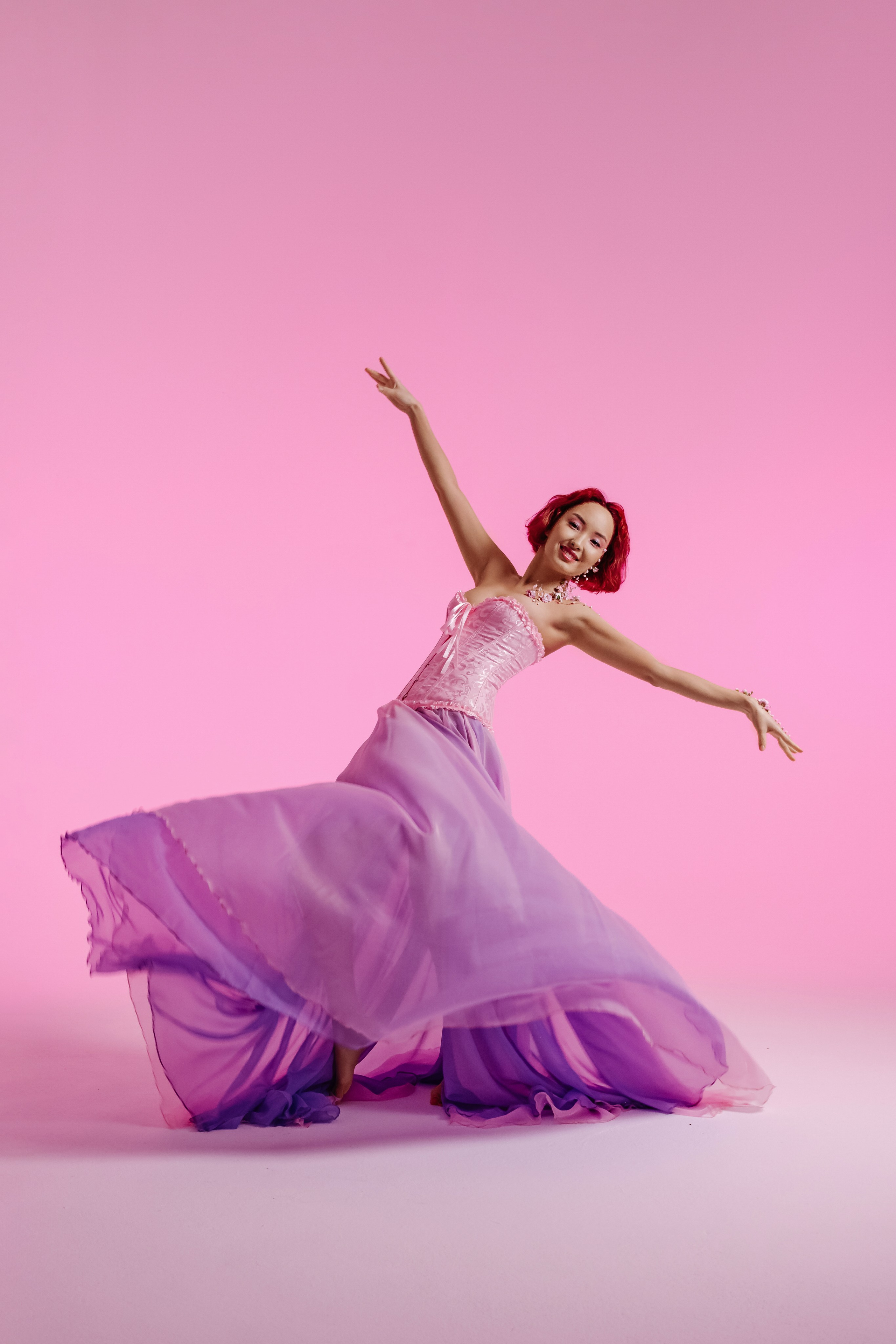 Нежный танец молодой женщины азиатской внешности, чье тело органично дополняют цветочные украшения, символизирующие весну.