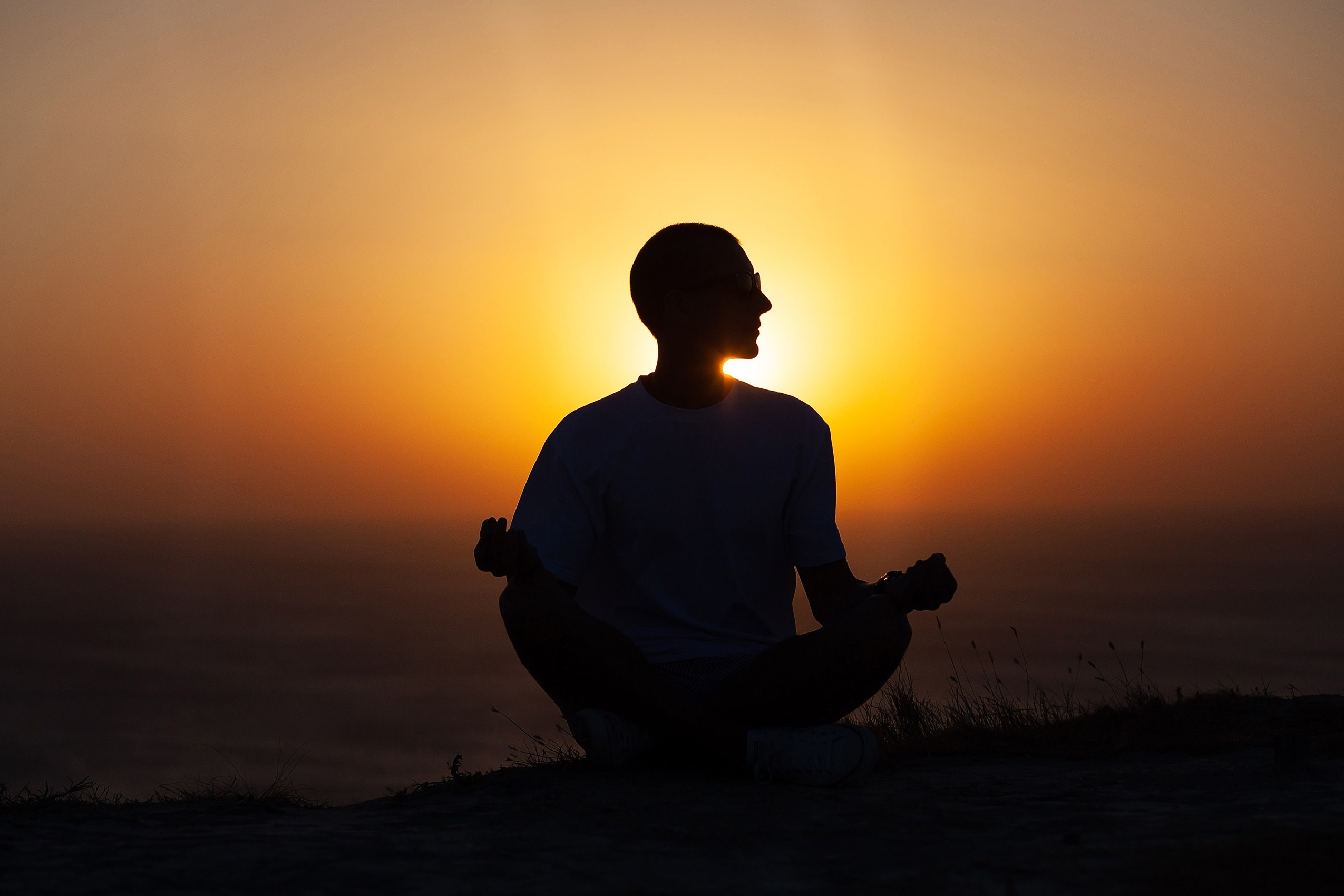 Темная фигура на фоне закатного солнца.