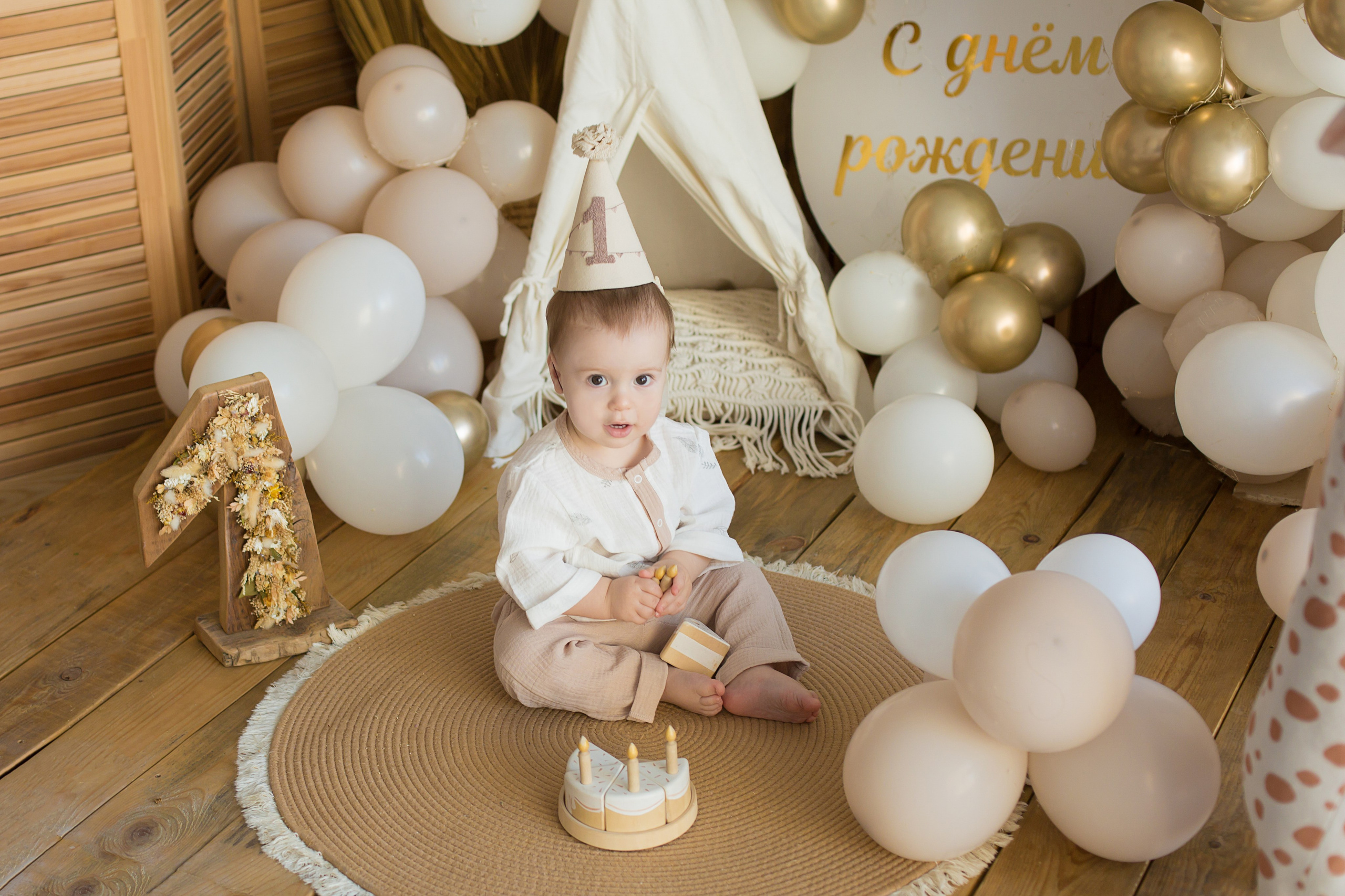 малыш сидит в шарах с цифрой 1