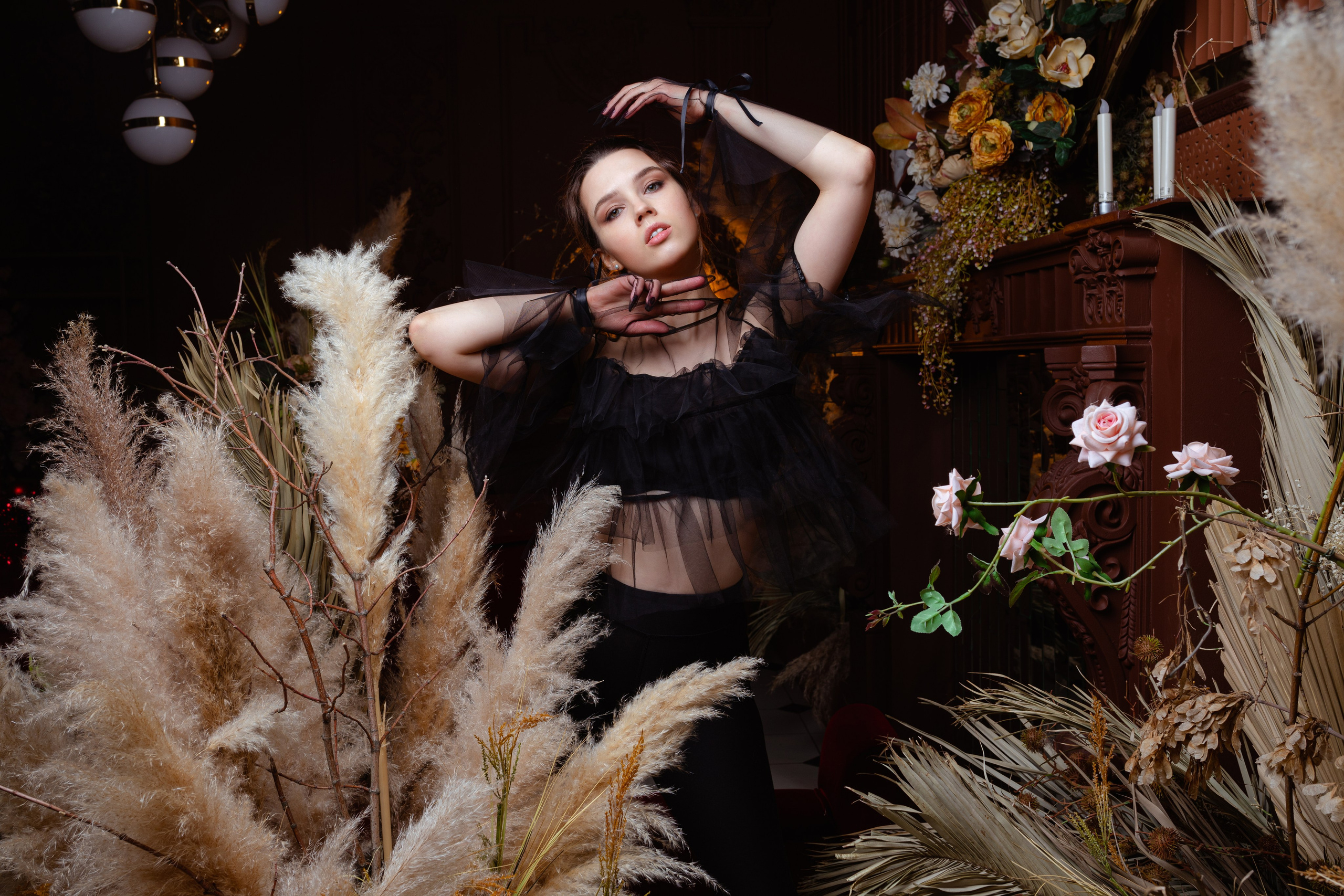 Девушка в стиле фэшен позирует среди кустов