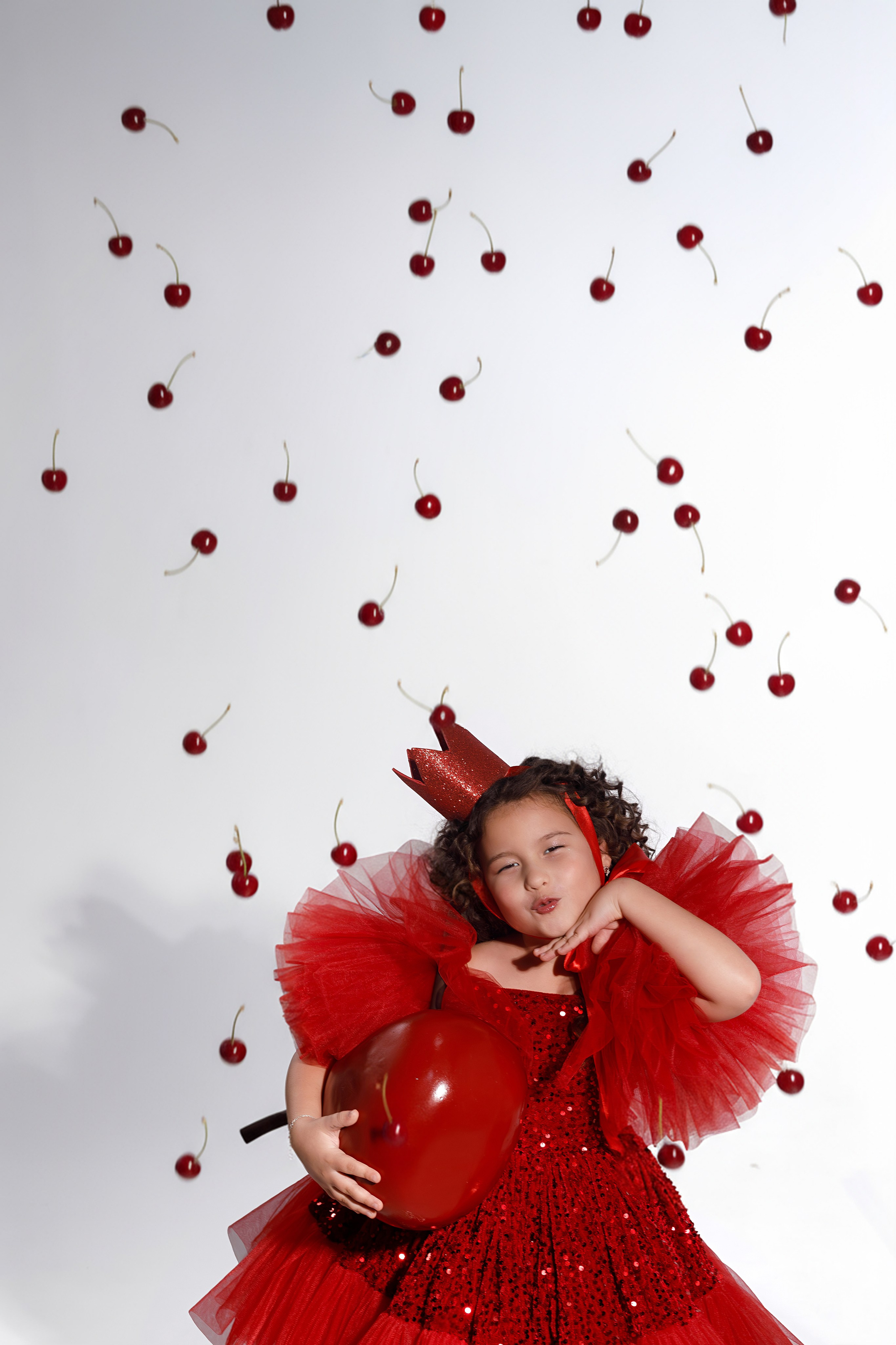 Вишни падают на девочку в красном платье