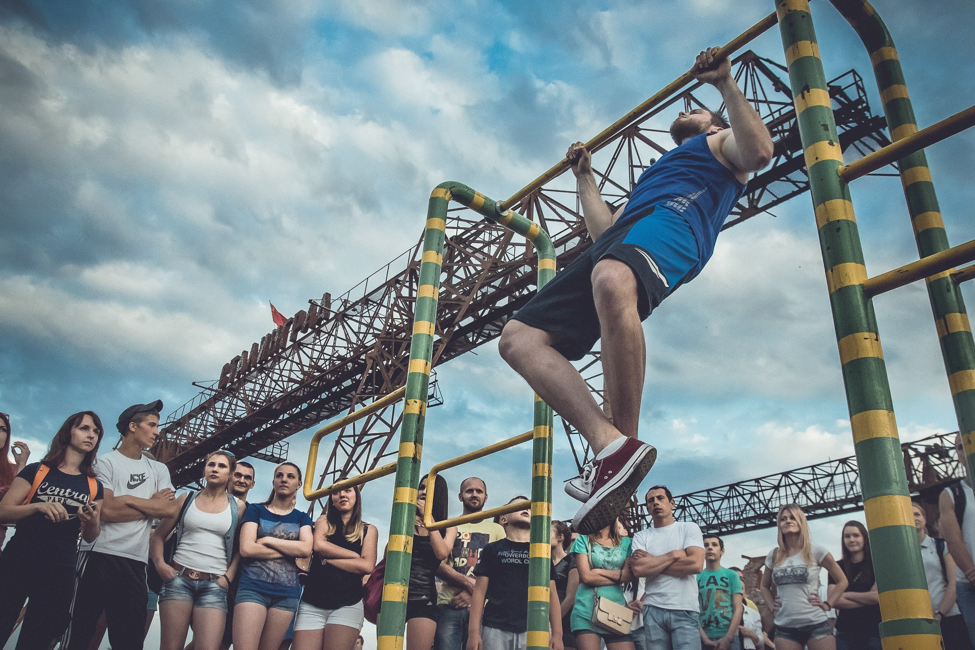 Спортсмен выполняет подтягивания на площадке байк-шоу