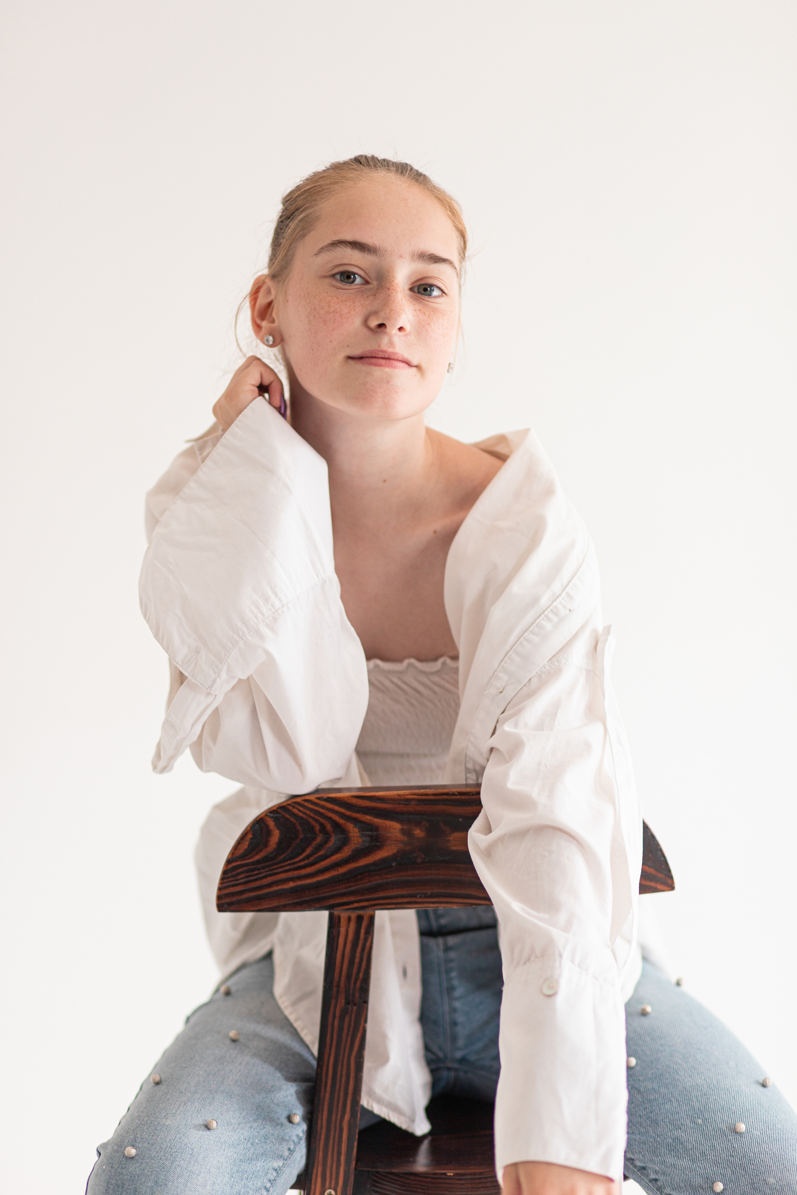 Девушка на барном стуле на белом фоне. Фотосессия во Владивостоке