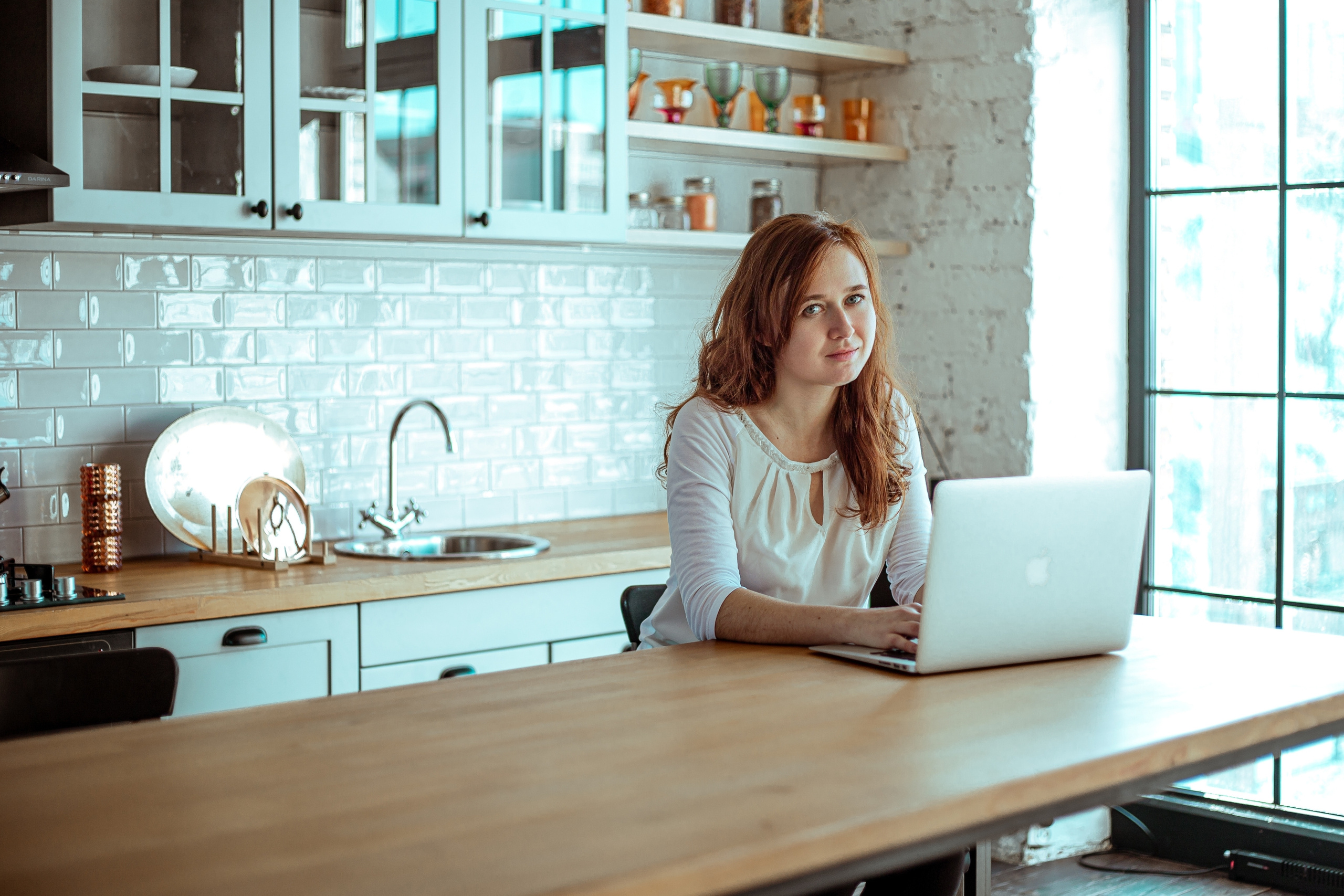 Рыжая девушка в студии за ноутбуком в фотостудии во Владивостоке