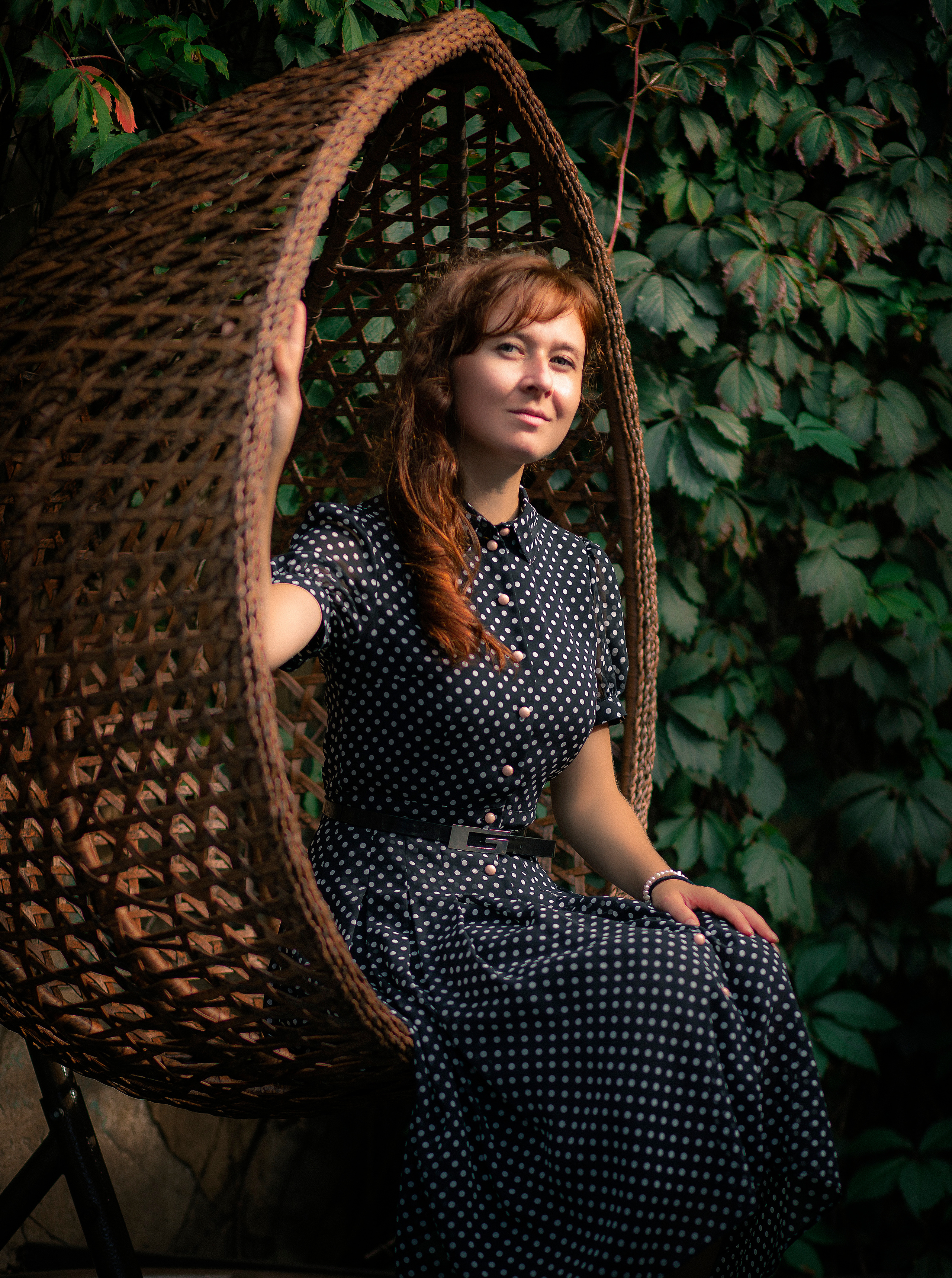 Рыжая девушка на качелях на фоне зелени в кафе фотосессия во Владивостоке