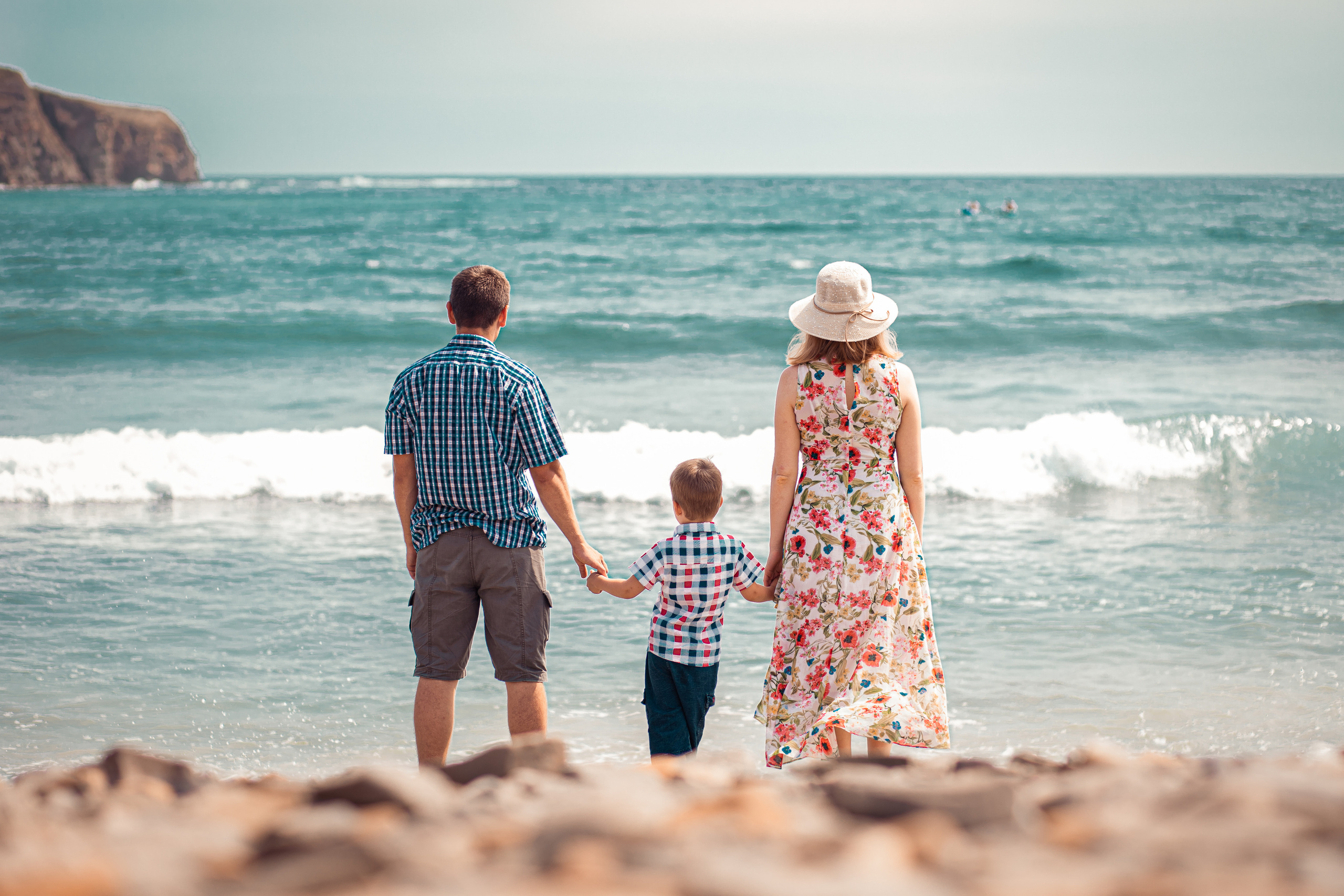 Семья держась за руки смотрят в море на фоне моря на Русском острове. Фотограф Иван Тарасов