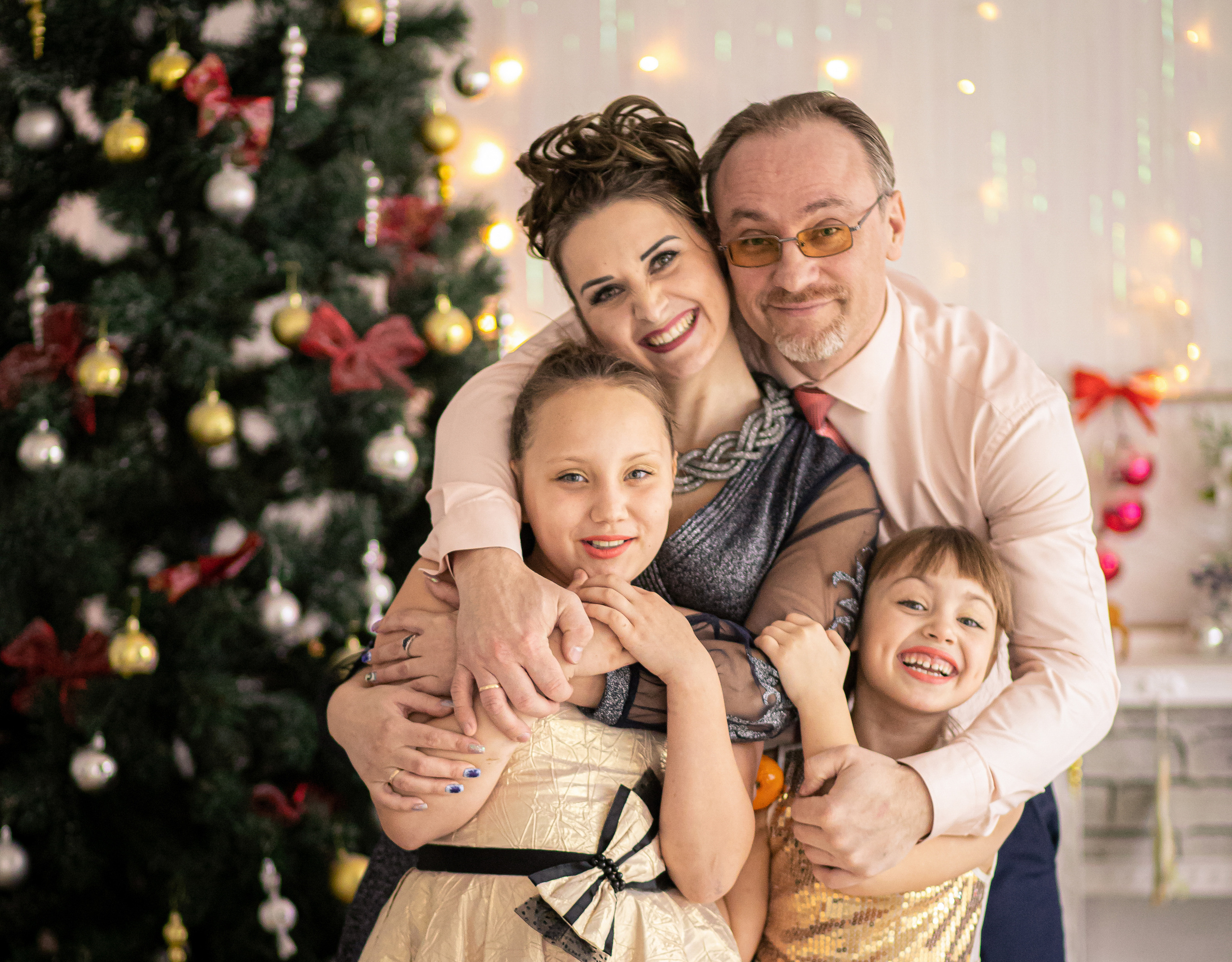 Счастливая семейная фотография семья на фоне ёлки в новый год во Владивостоке