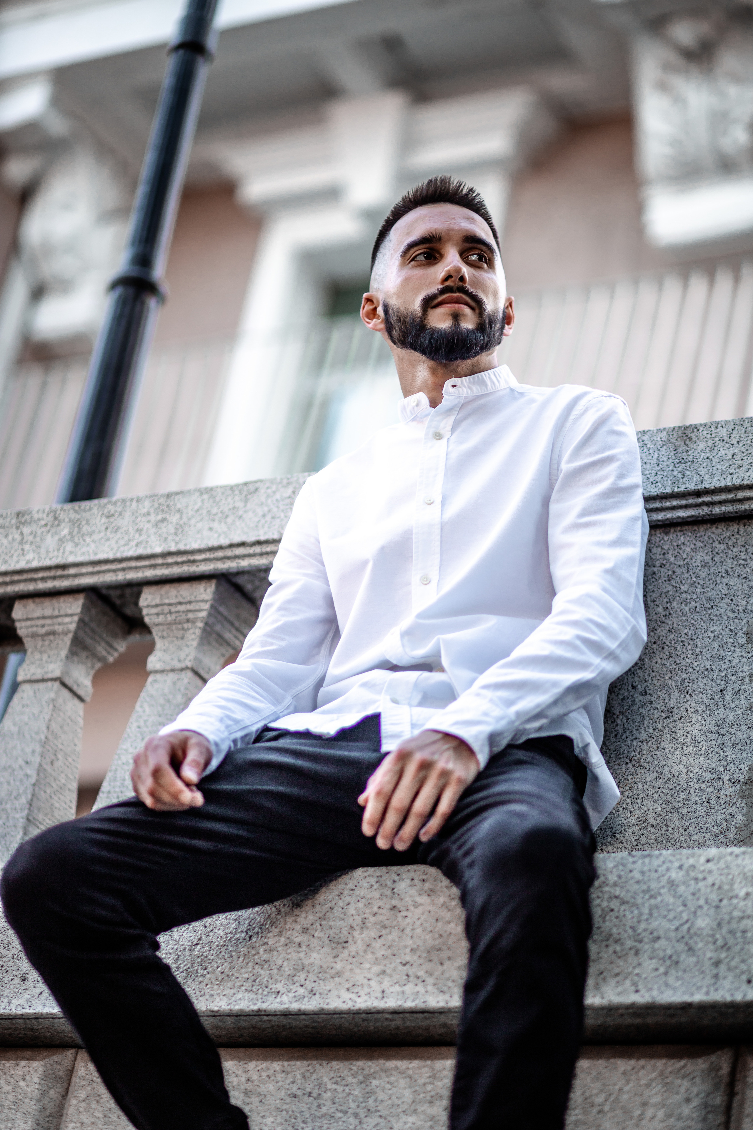 Модная мужская фотография парень в белой рубашке сидит на парапет серая лошадь владивосток