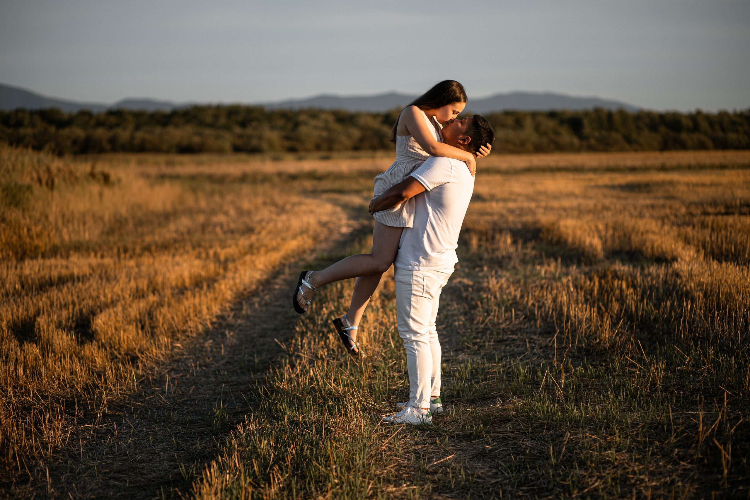 Влюблённая пара в поле целуются парень держит девушку на руках на закате во Владивостоке