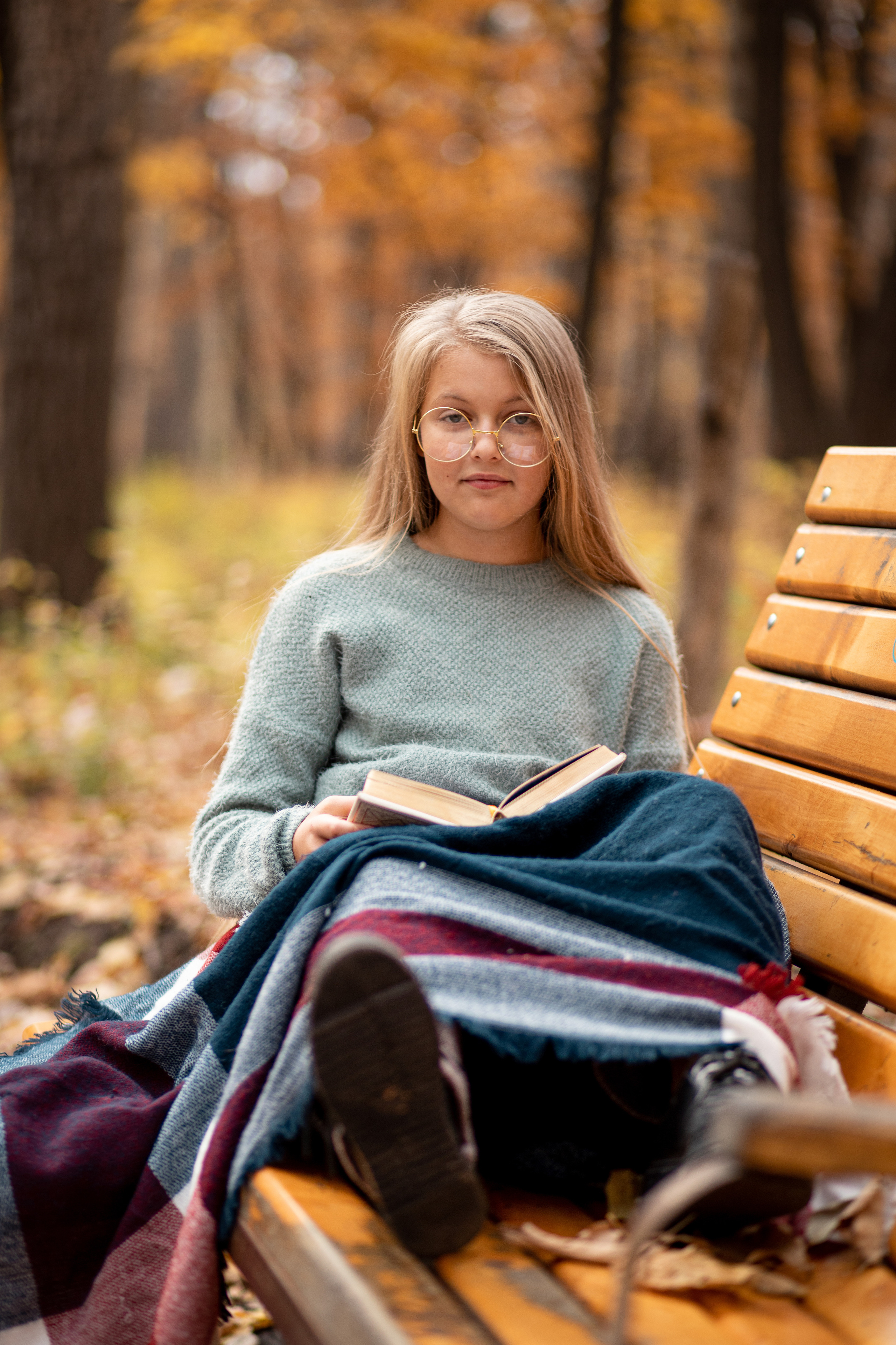 Девочка в очках читает книгу на лавочке. Детский фотограф во Владивостоке