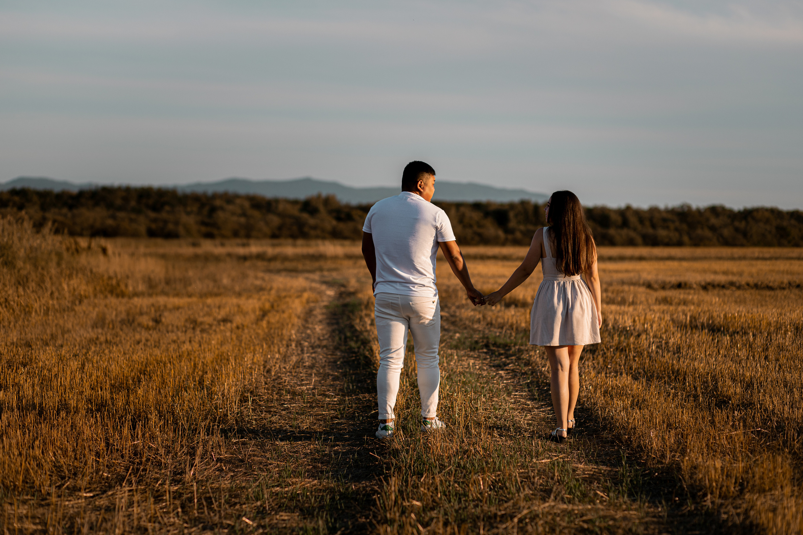 Парень и девушка держатся за руки и идут по дороге в даль фотосессия влюблённых во Владивостоке