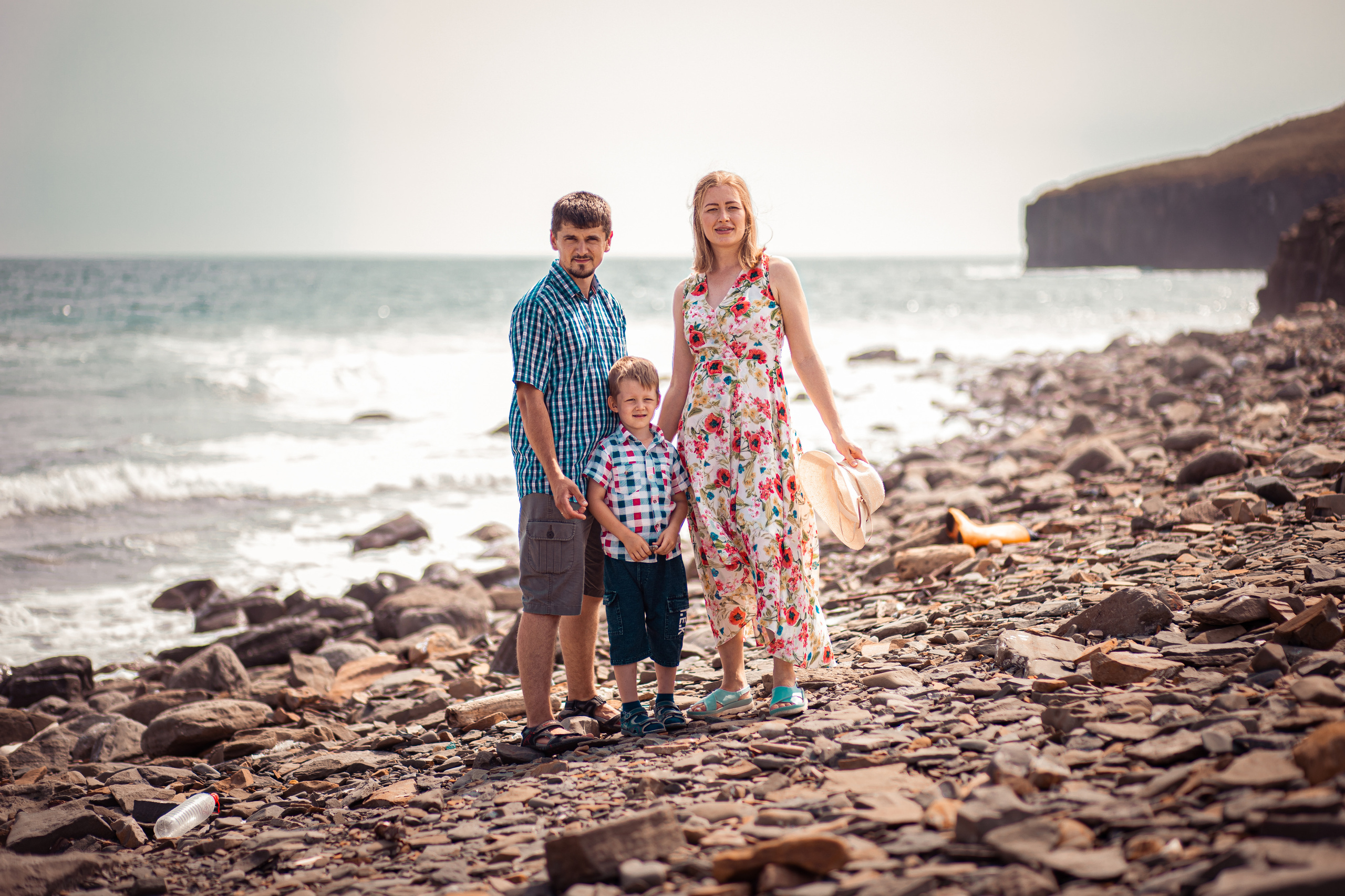 Молодая семья стоит на побережье мыса на Русском острове во Владивостоке