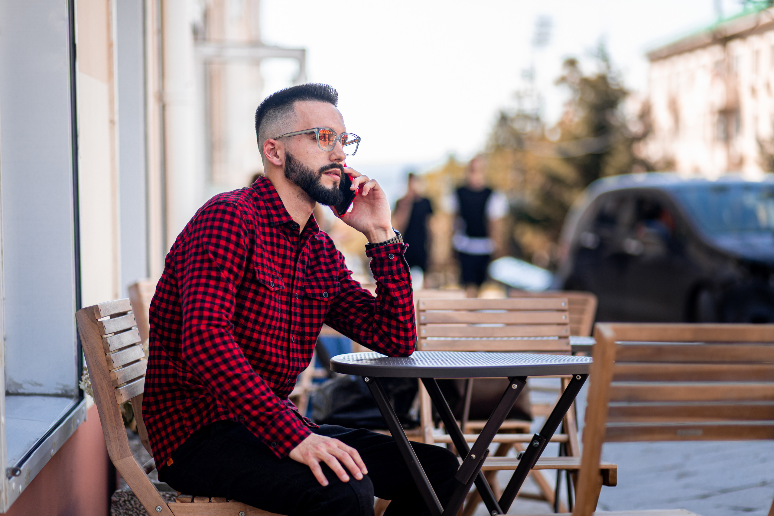Деловая фотография мужчина разговаривает по телефону сидит в уличном кафе во Владивостоке