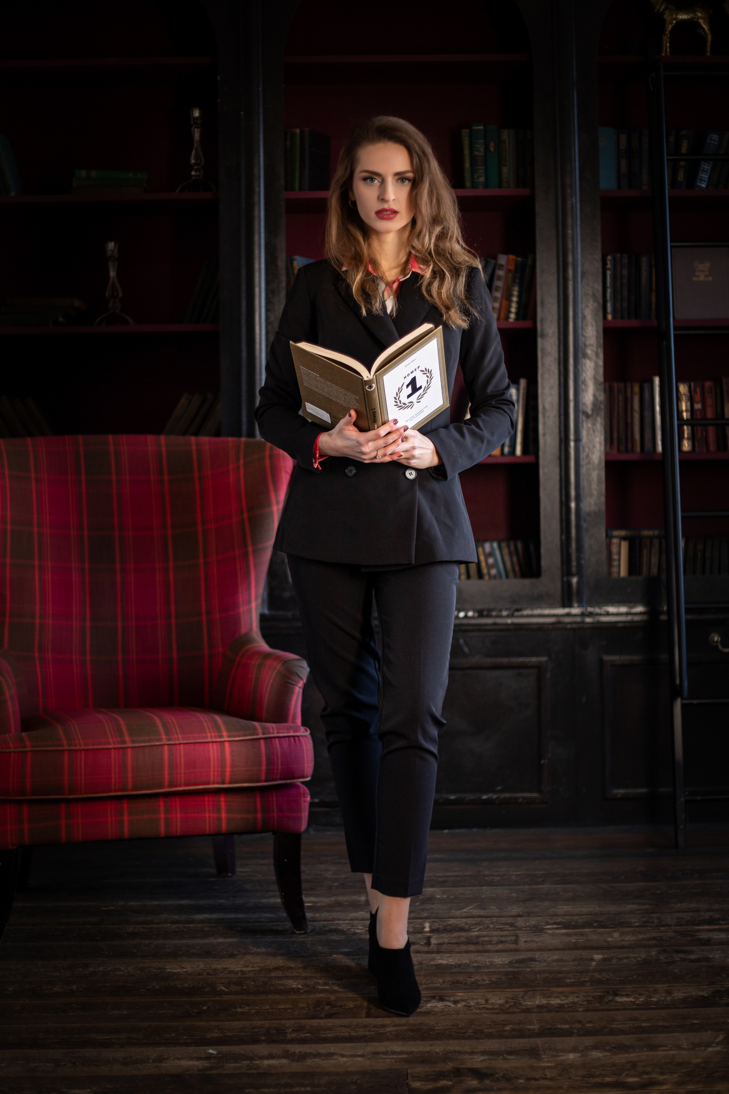 Бизнес фотография девушка на фоне тёмной студии с книгой в руках