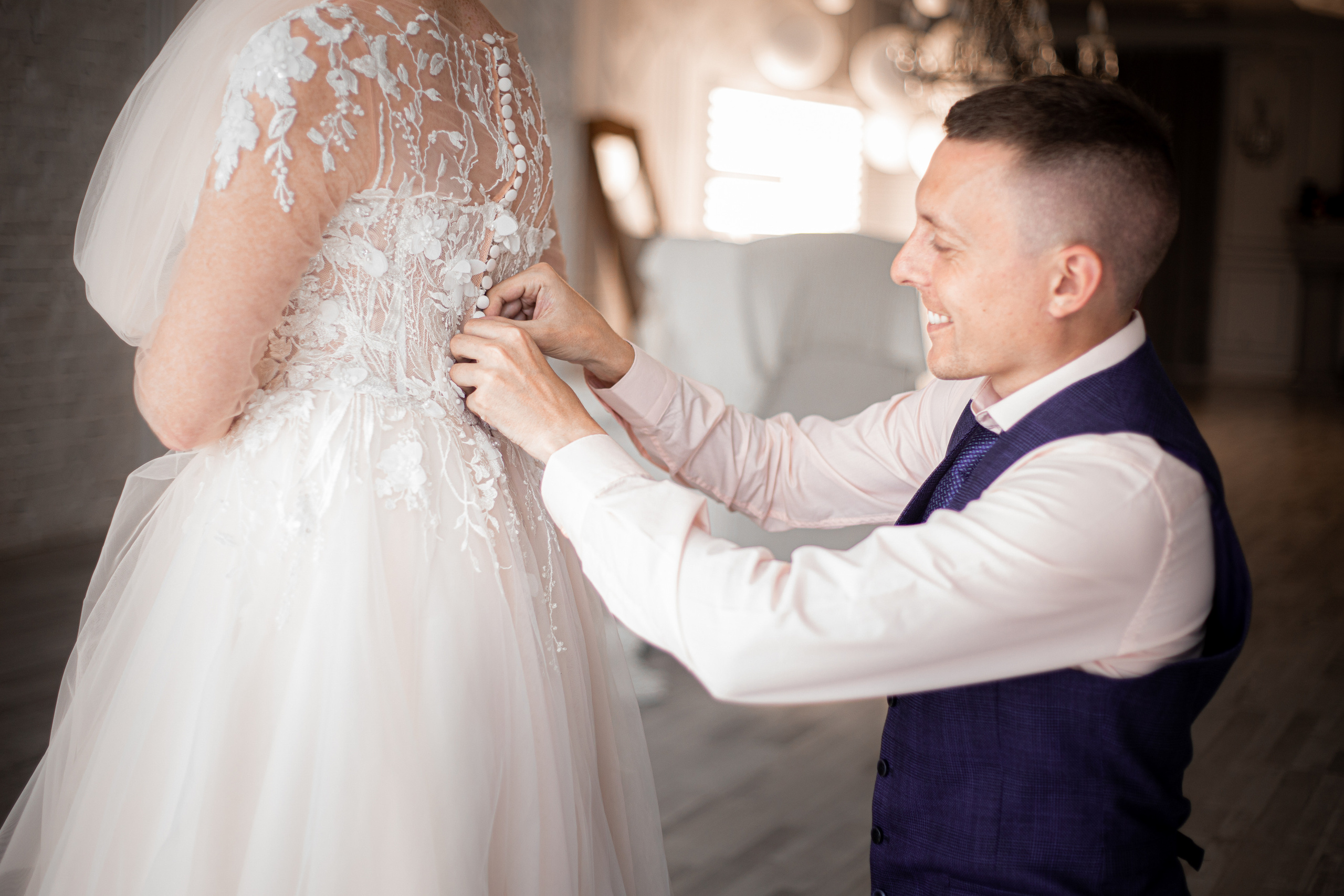 Жених застёгивает платье невесте в студии Photozone во Владивостоке сборы