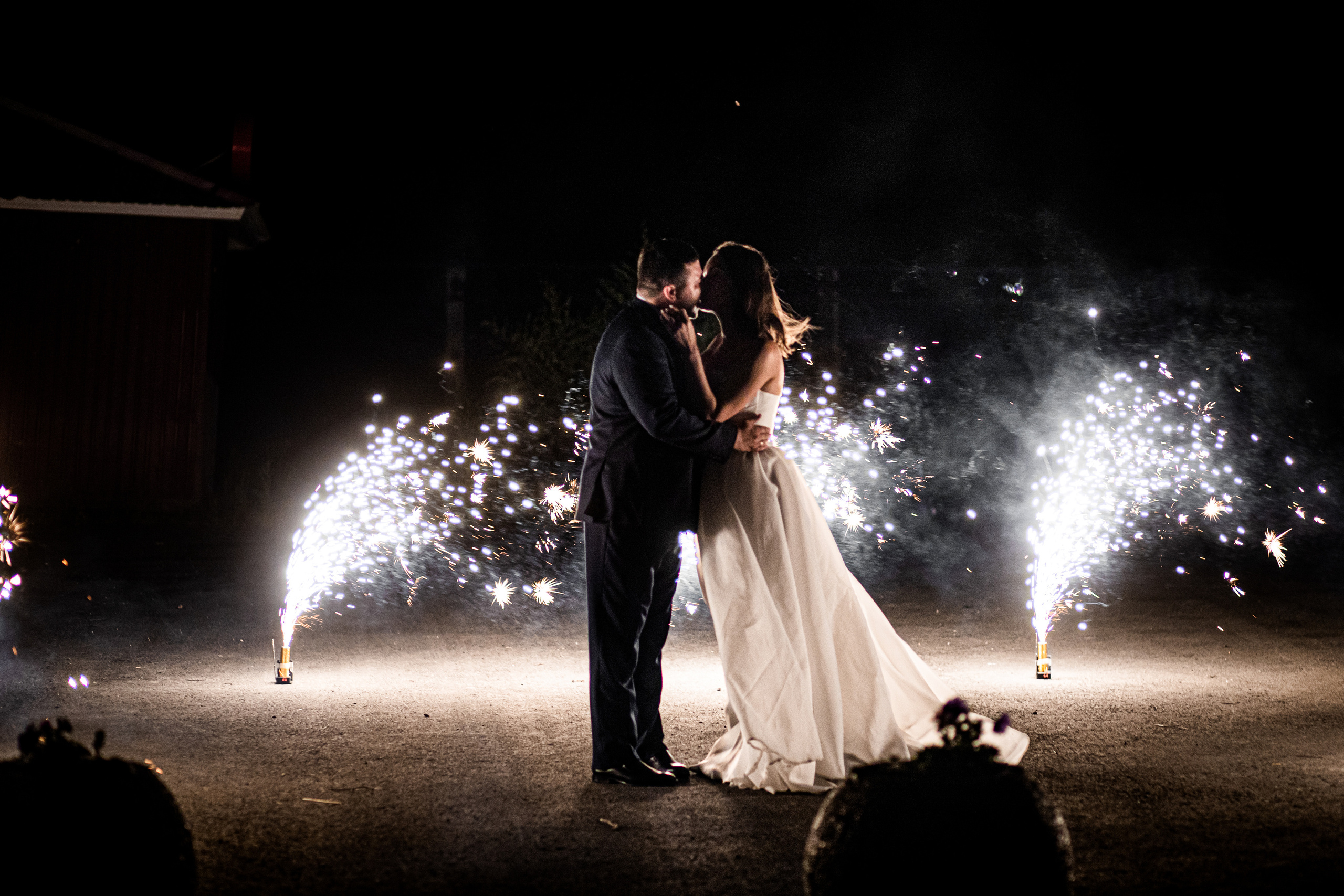 Молодая пара целуется ночью среди холодных фонтанов свадьба