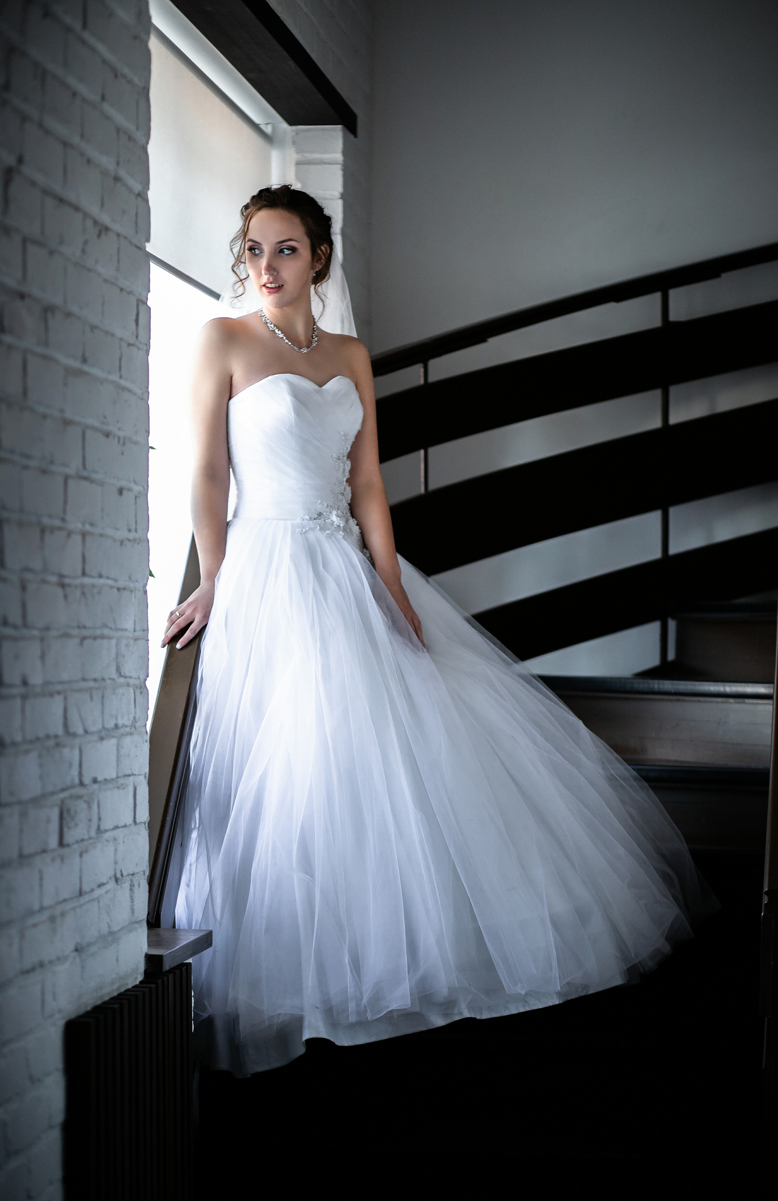 Высокая невеста смотрит в окно свадебная фотосессия в отеле от Ивана Тарасова