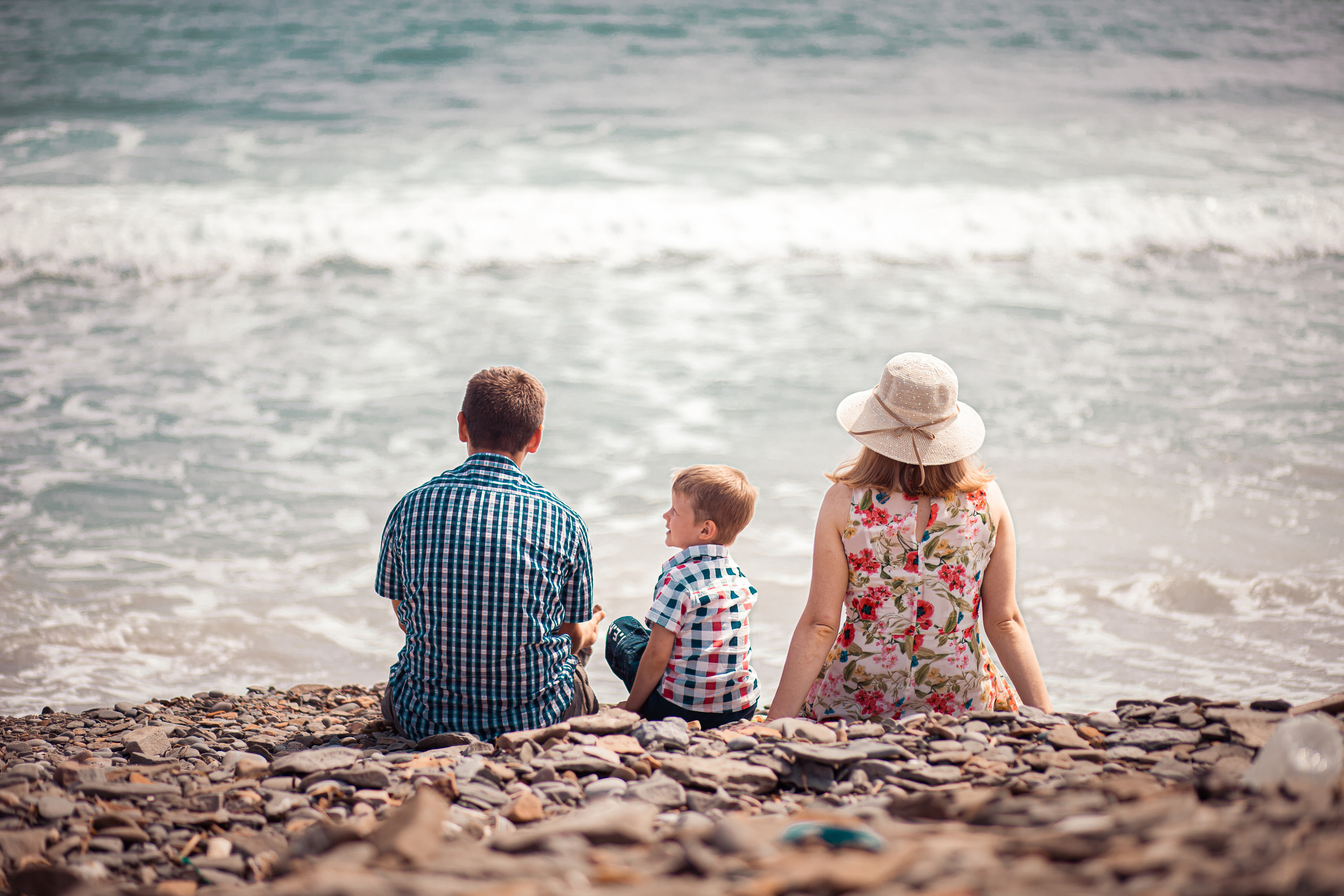 Сын спрашивает что-то у отца сидя на побережье родители смотрят в море семейная фотосессия Владивосток