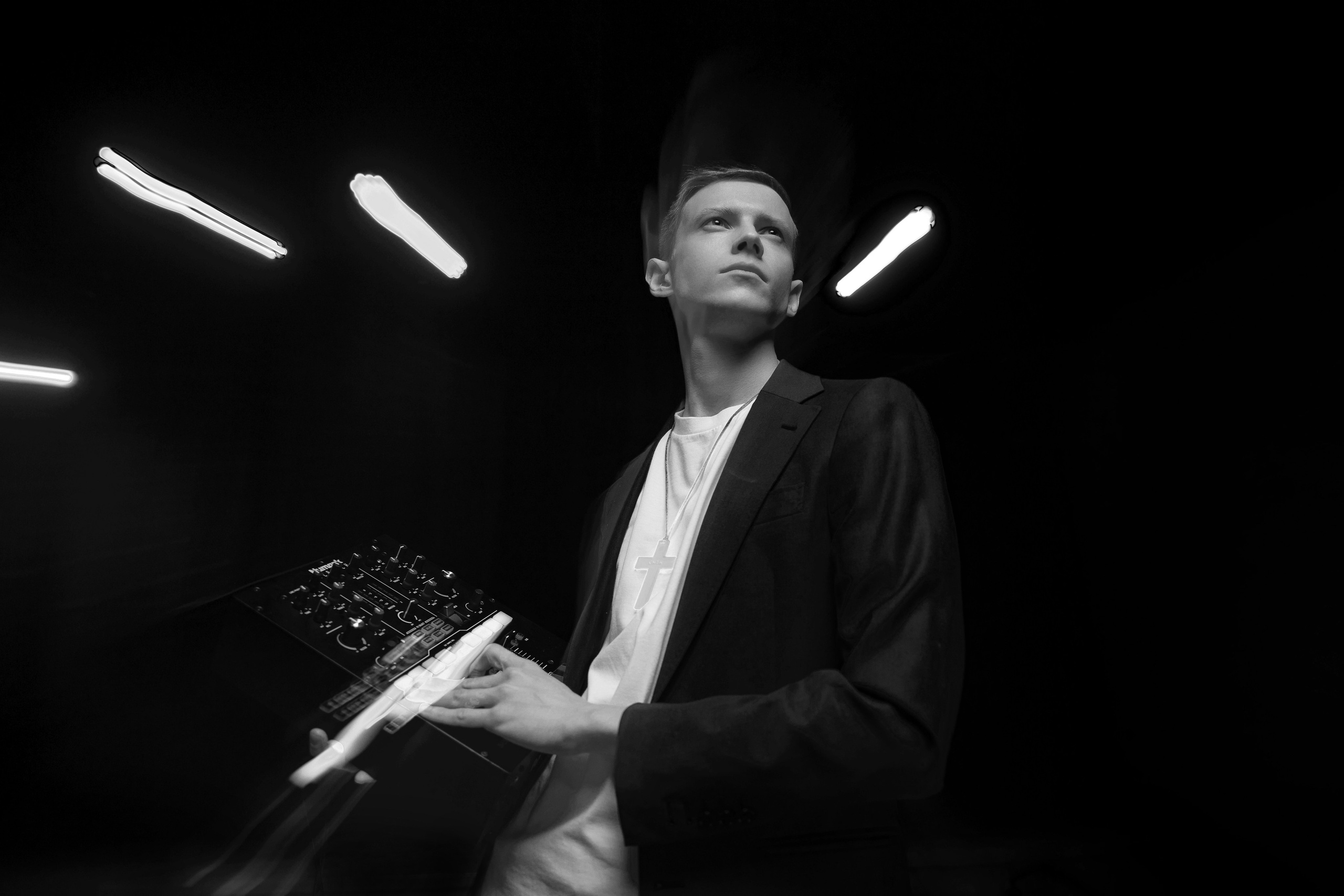 Парень диджей держит в руках микшер