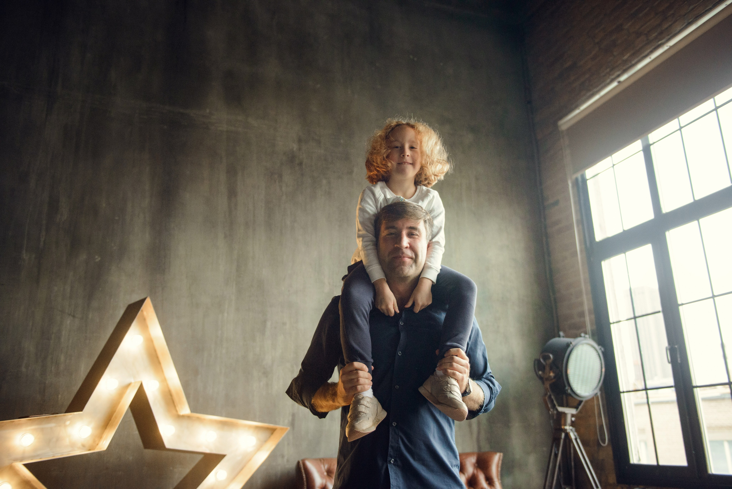 dad and daughter in a dark photo studio