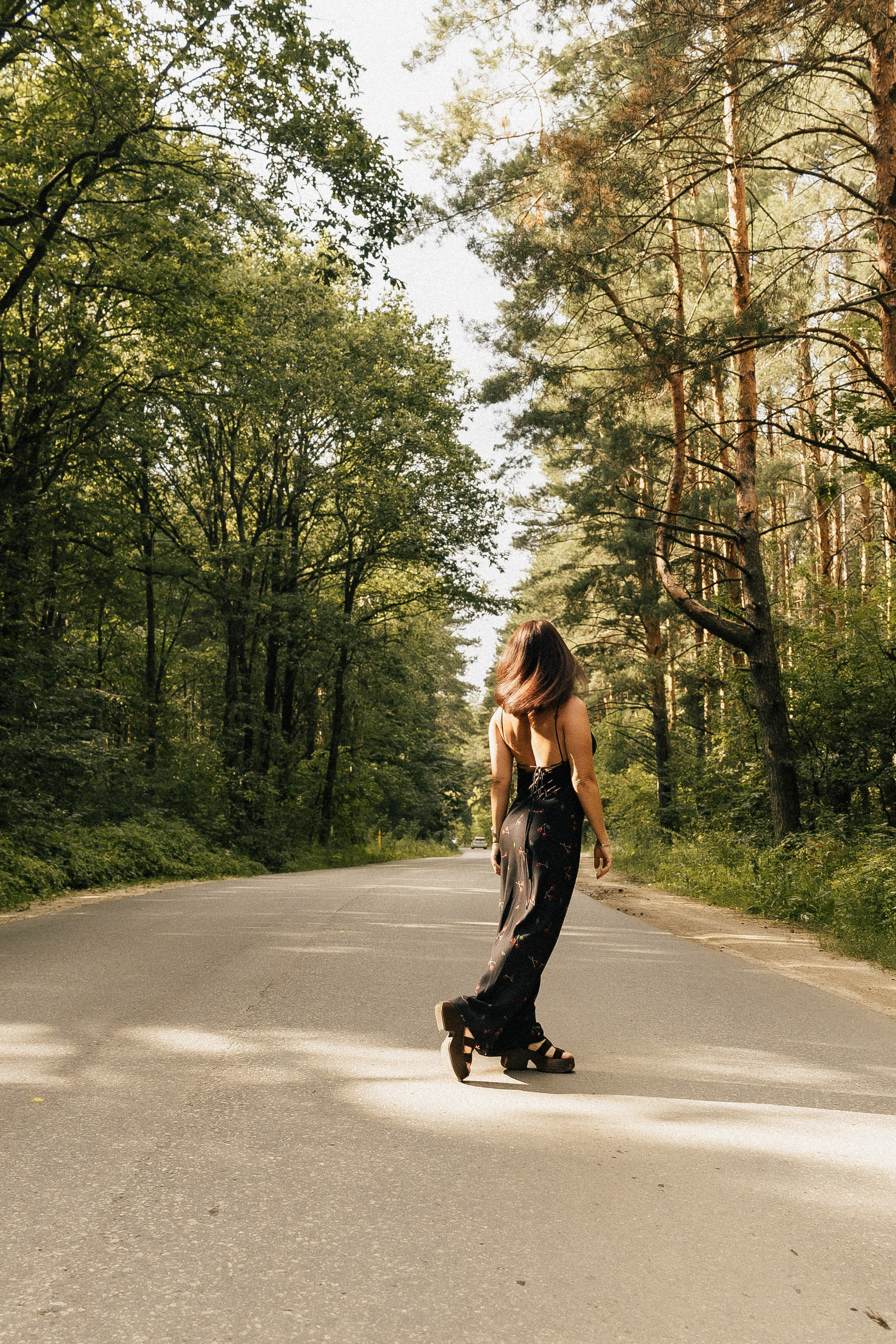 Девушка в черном платье идет по лесной дороге, вид со спины. Фотограф в Пензе Александра Овечкина