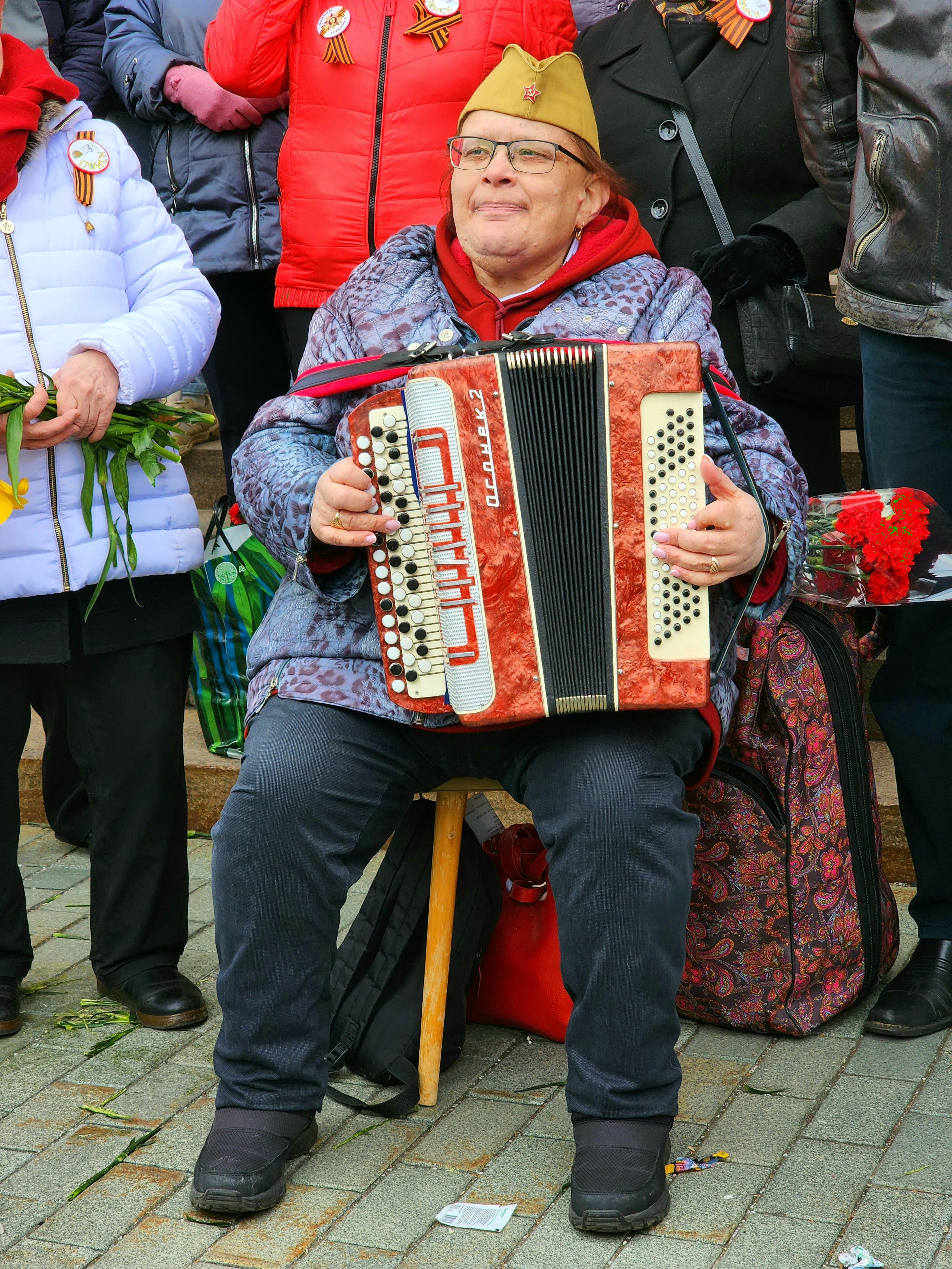 Женщина играет на аккордеоне в день победы