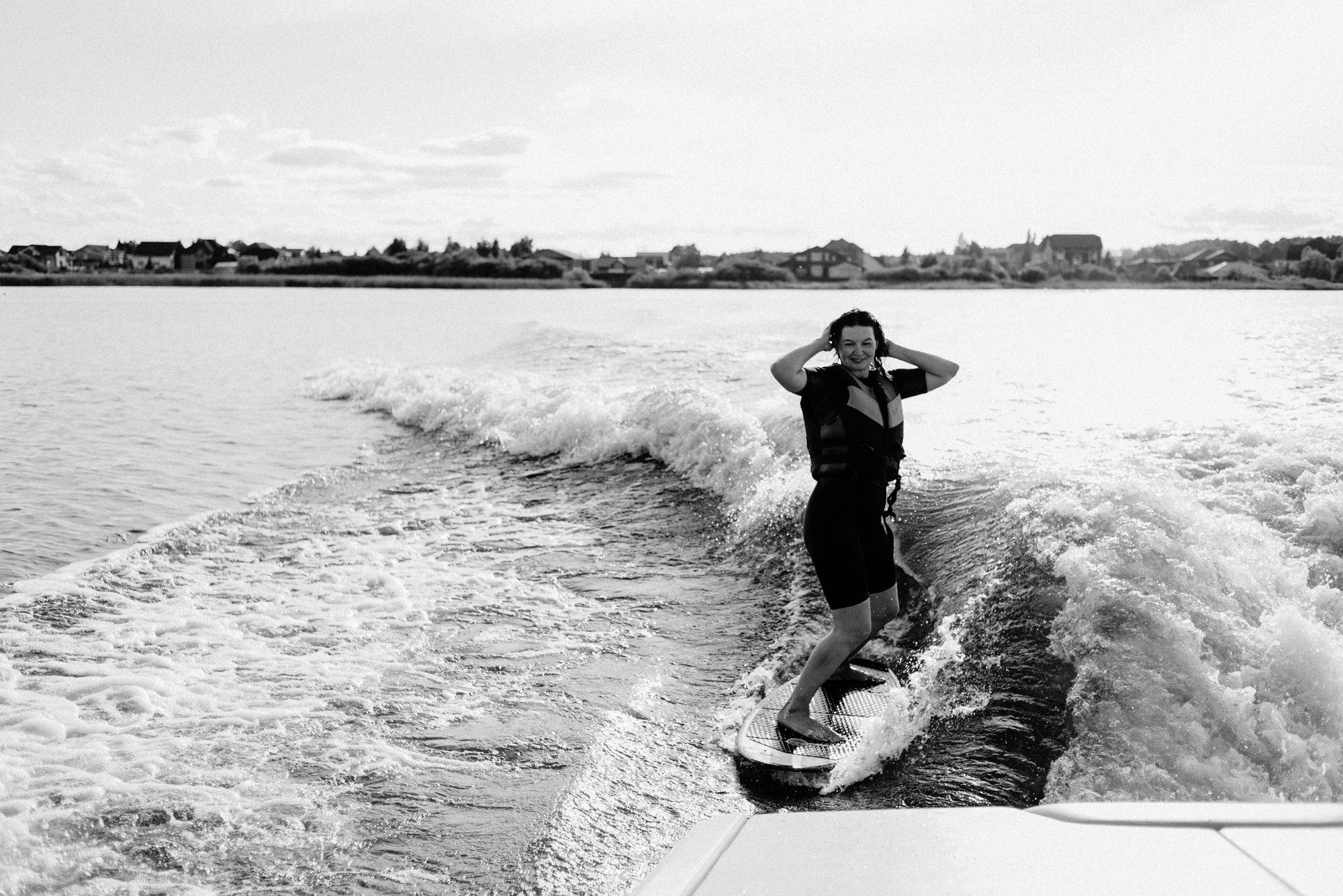 Съемка в стиле лайфстайл на воде в Тюмени, девушка плавает с вейксерфом в вечернем свете озера