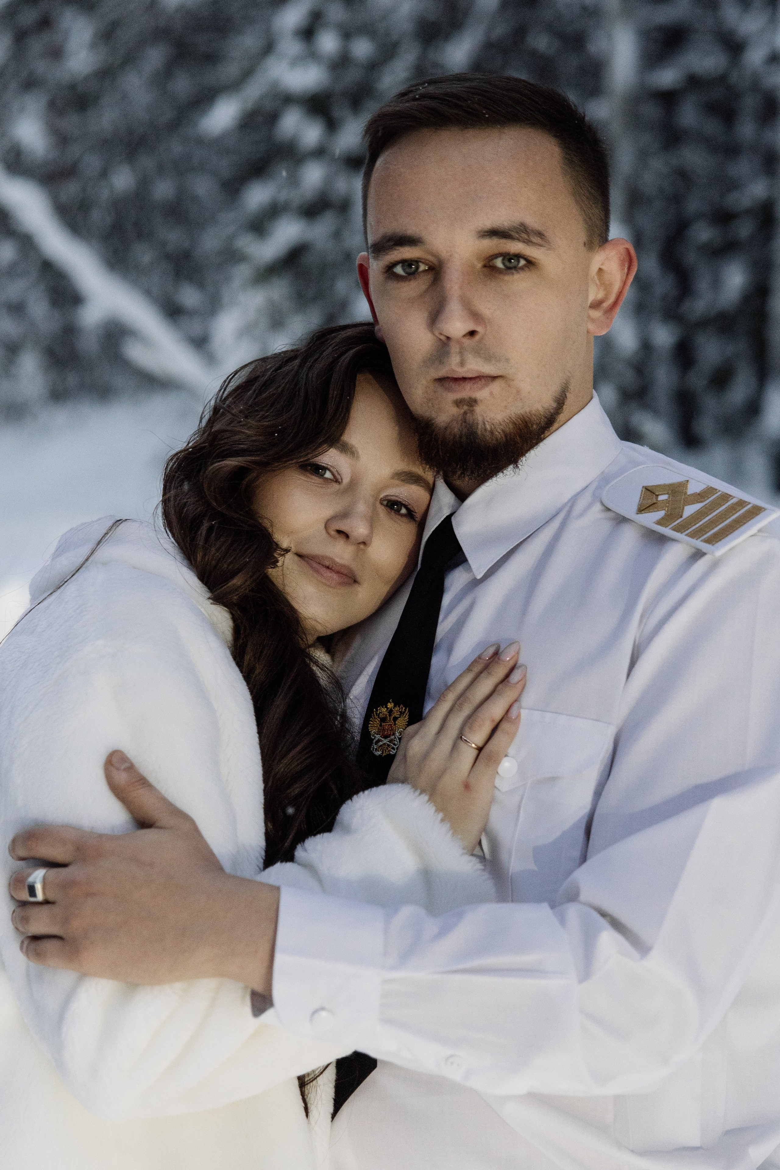 Свадебная фотосессия зимой — жених и невеста обнимаются в зимнем лесу